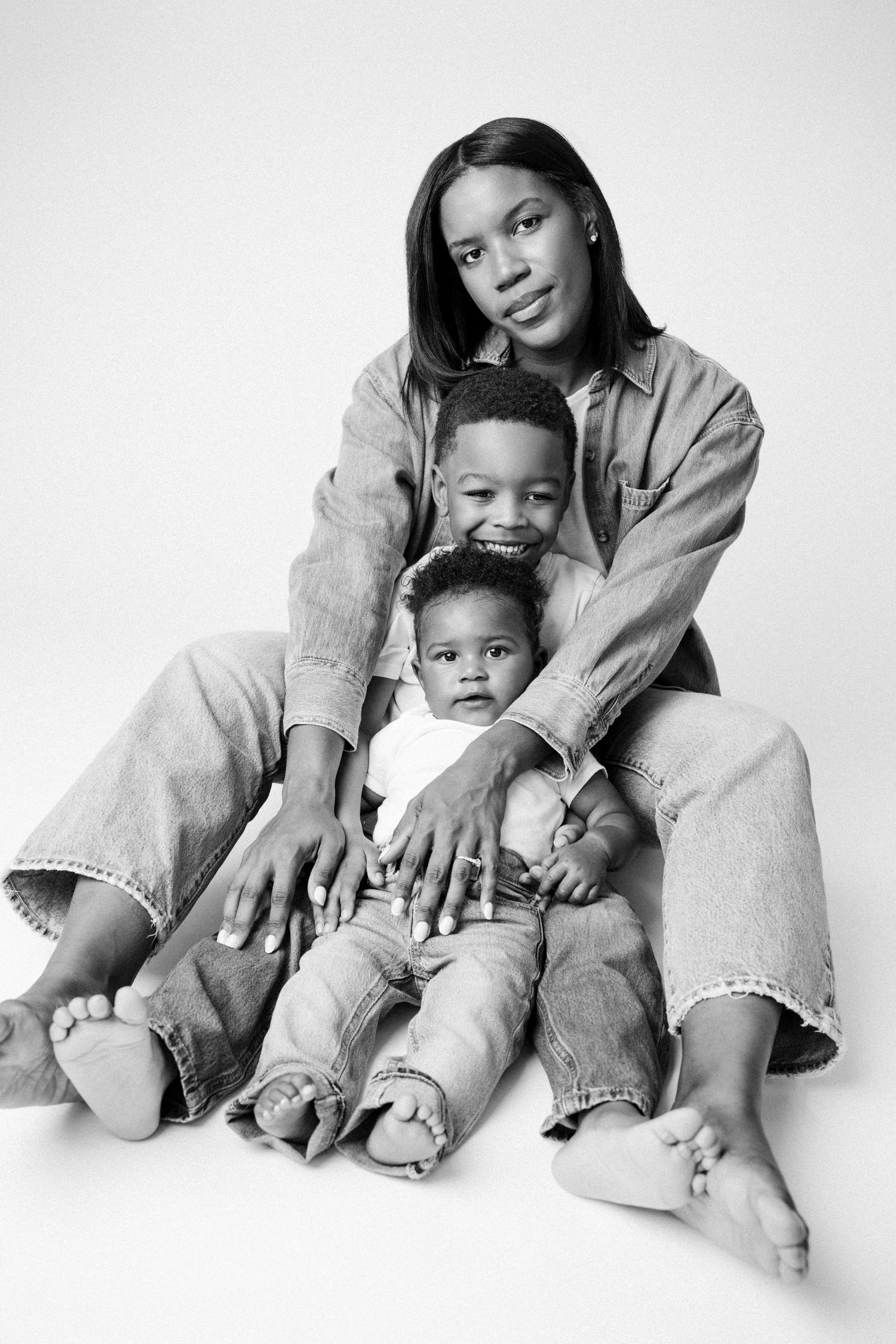 Black and white portrait series showing tender moments between parent and child in matching denim outfits.