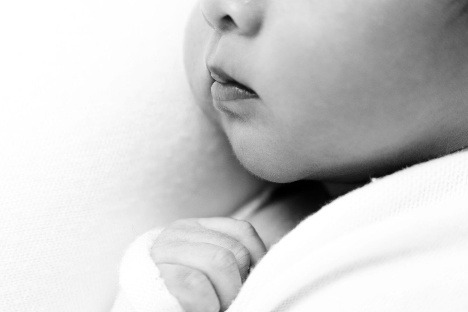 Extreme close-up black and white portrait study showing facial features in soft focus.