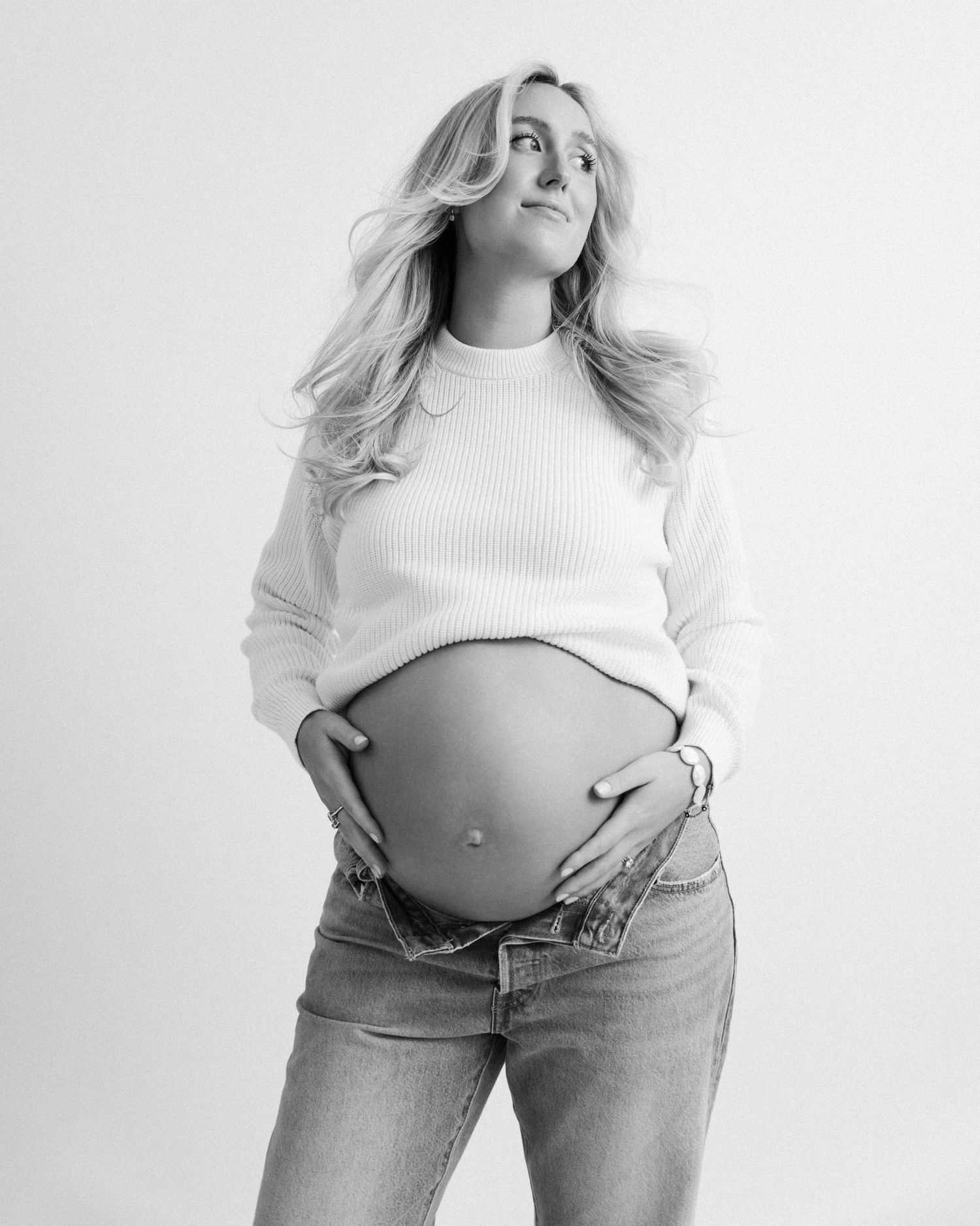 A series of black and white photos showing a person in jeans and a cropped sweater against a white background.