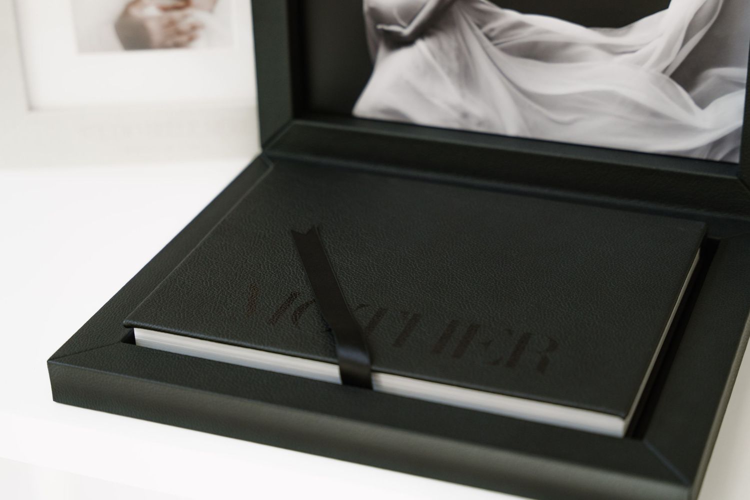 Black luxury watch box opens to reveal a sleek timepiece nestled in plush interior padding.