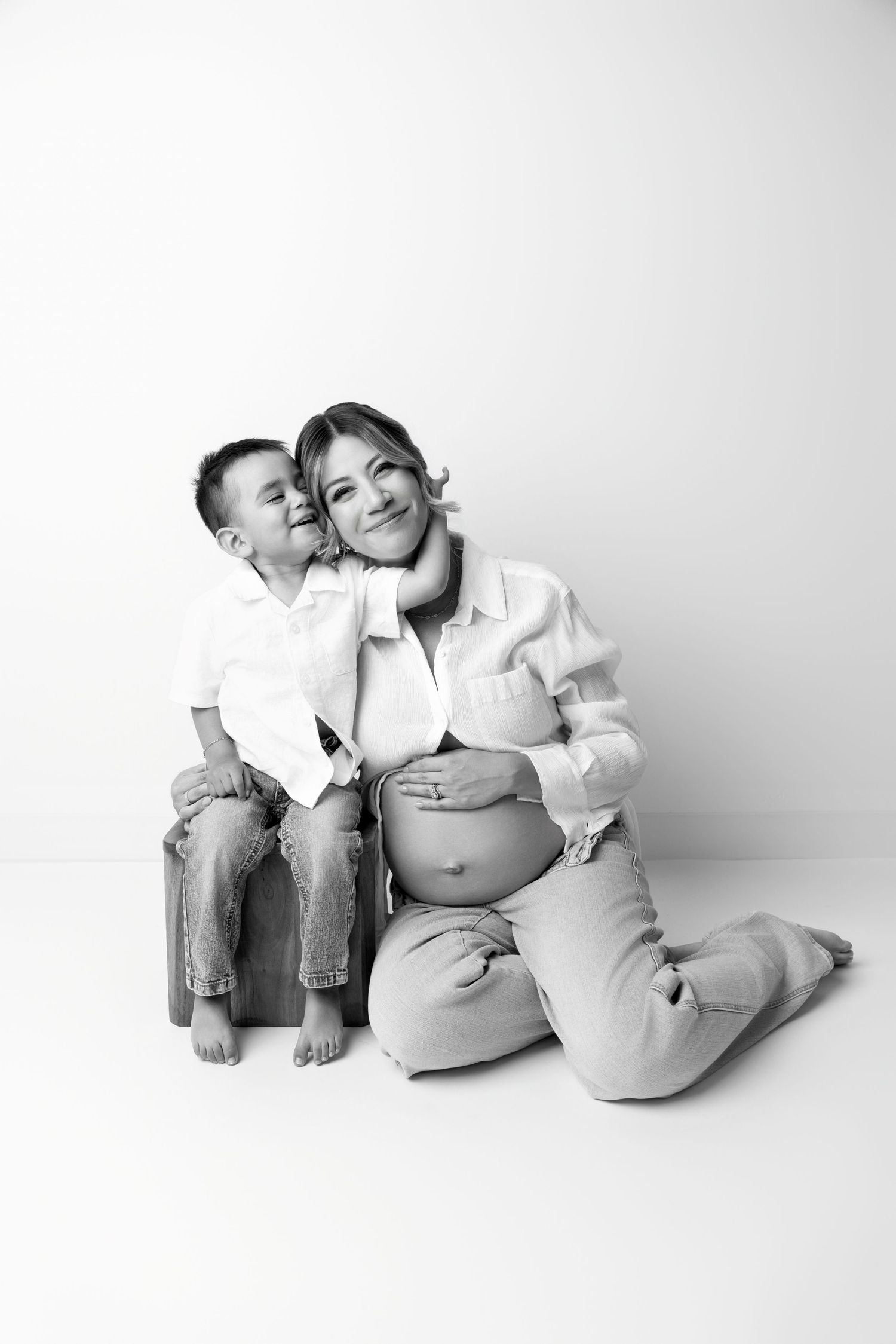 A series of black and white photographs showing tender moments between two people sitting and reclining together.