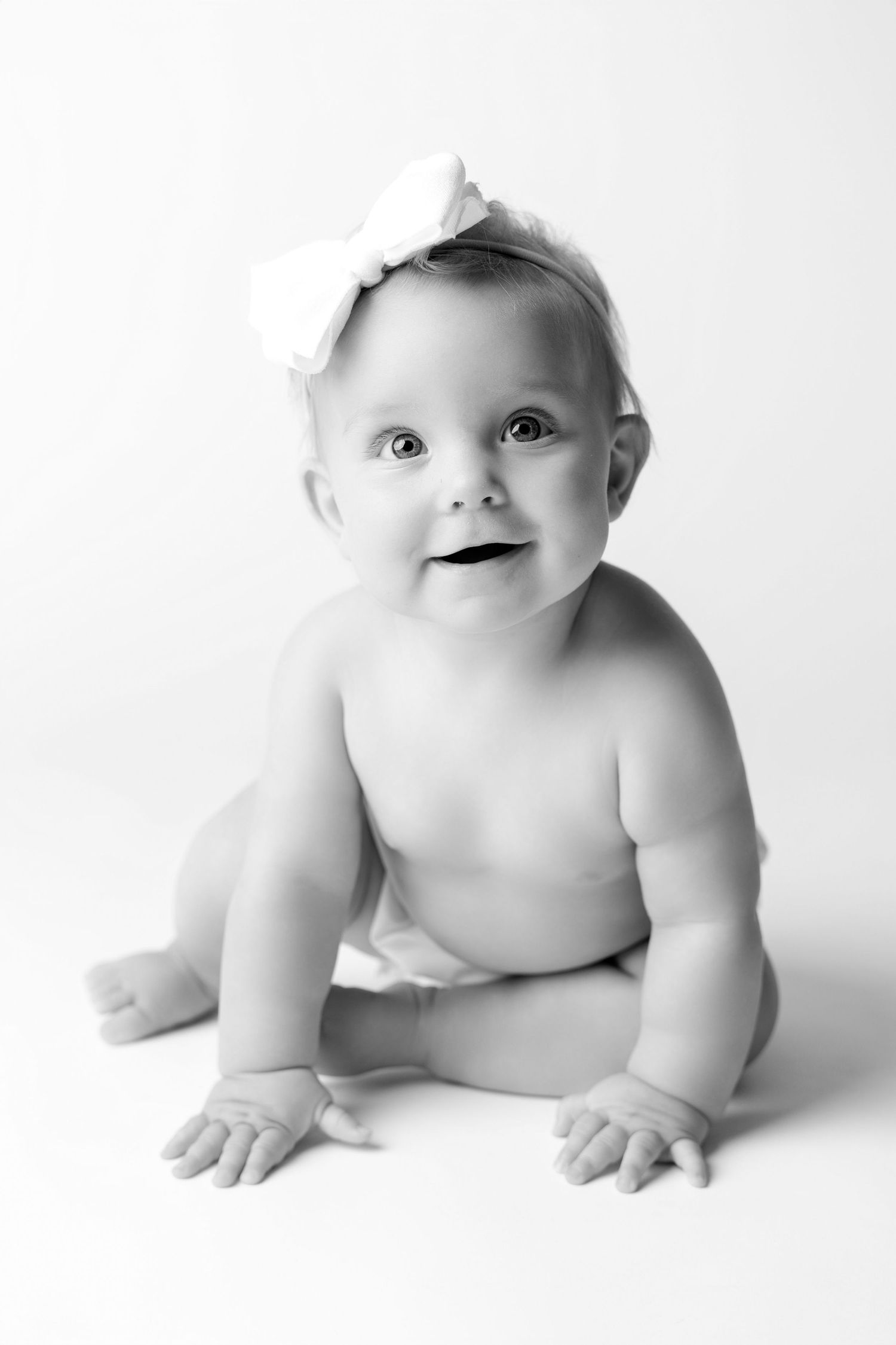 A series of black and white photos showing a crawling baby in various poses against a white background.