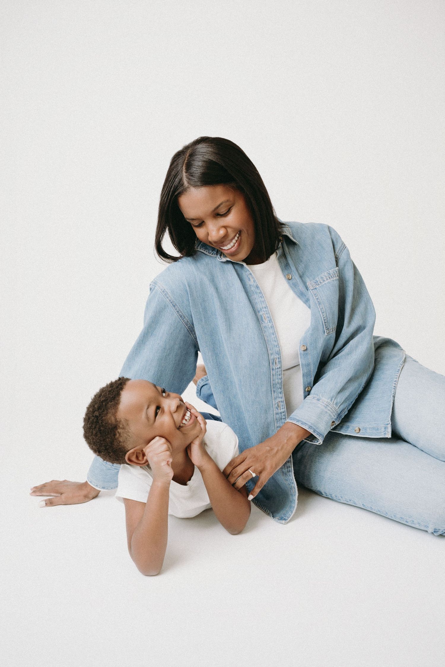 A mother and child share tender moments in matching denim outfits against a white backdrop in a series of photos.
