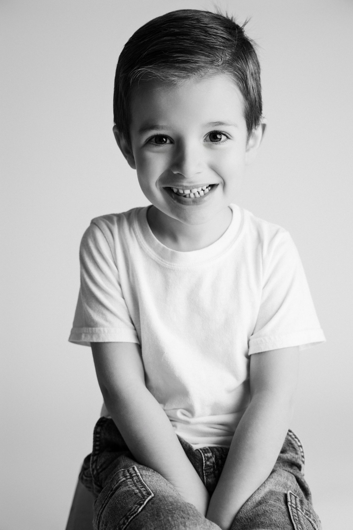 Black and white studio portraits showing cheerful expressions in white t-shirt.
