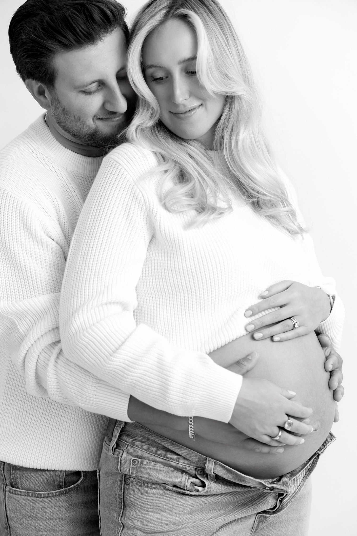 A couple in white sweaters and jeans share intimate moments in a minimalist photo series.