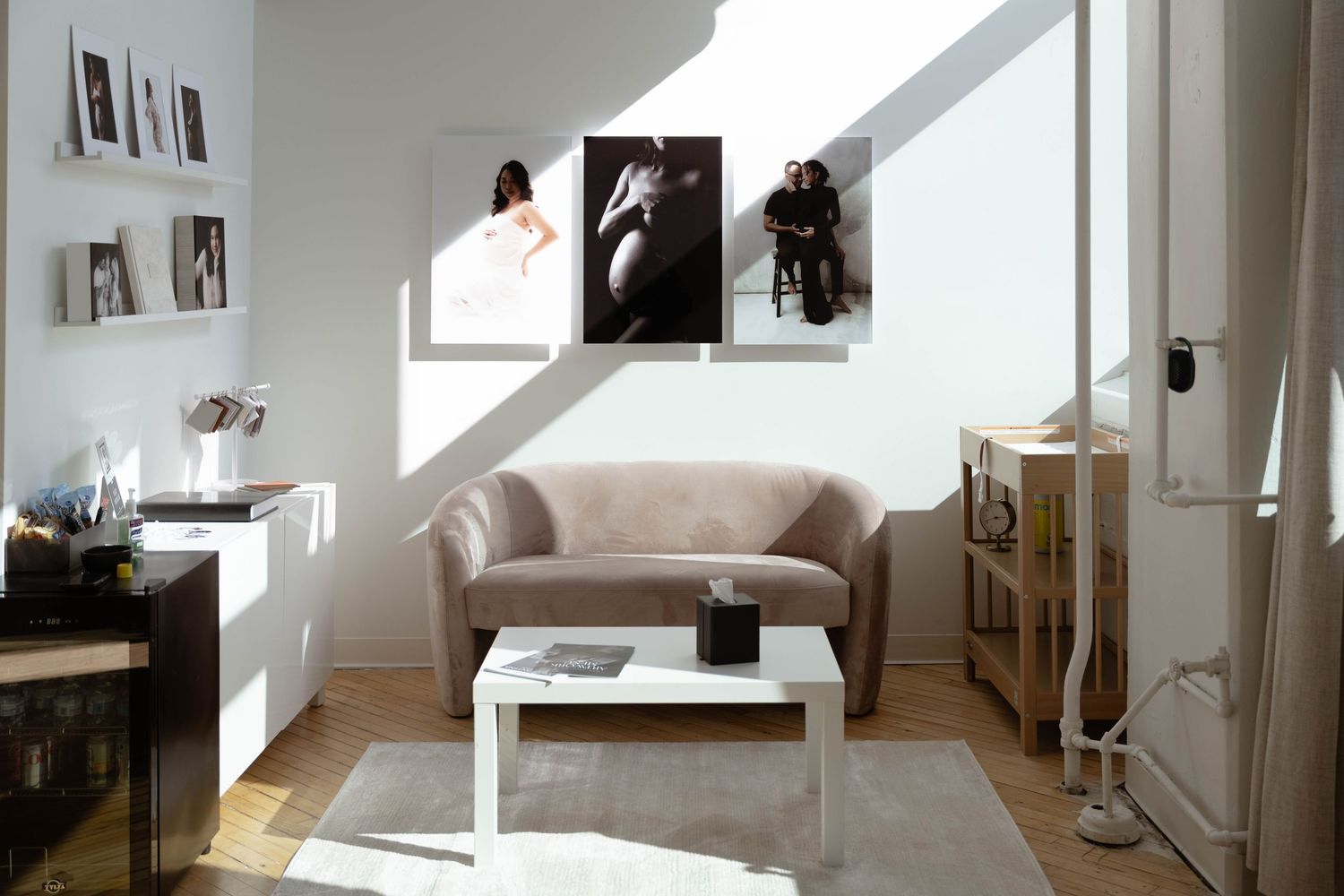 Photography studio space with natural lighting and artwork displayed on white walls.