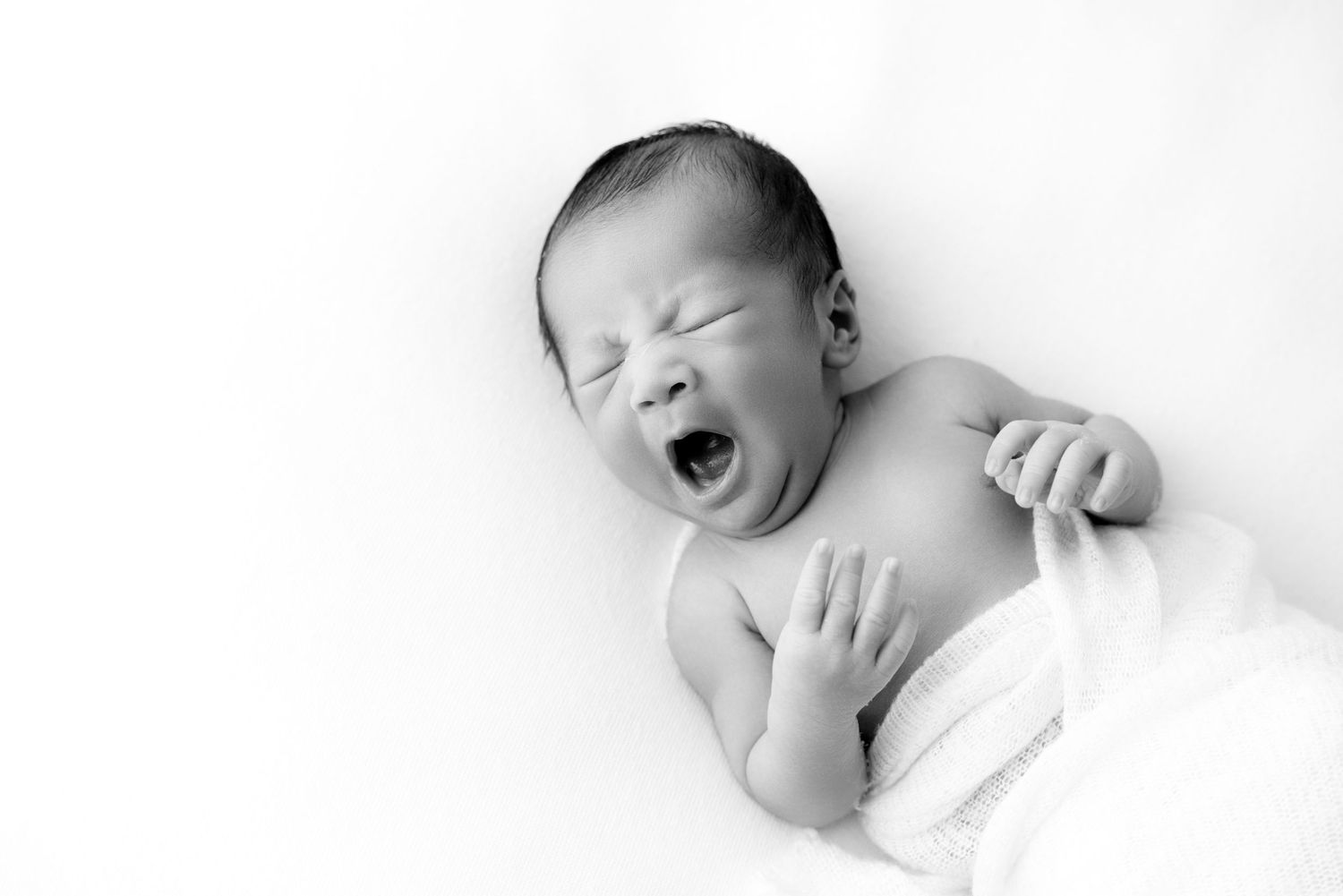 Series of black and white photos showing sleeping newborn in minimalist style.