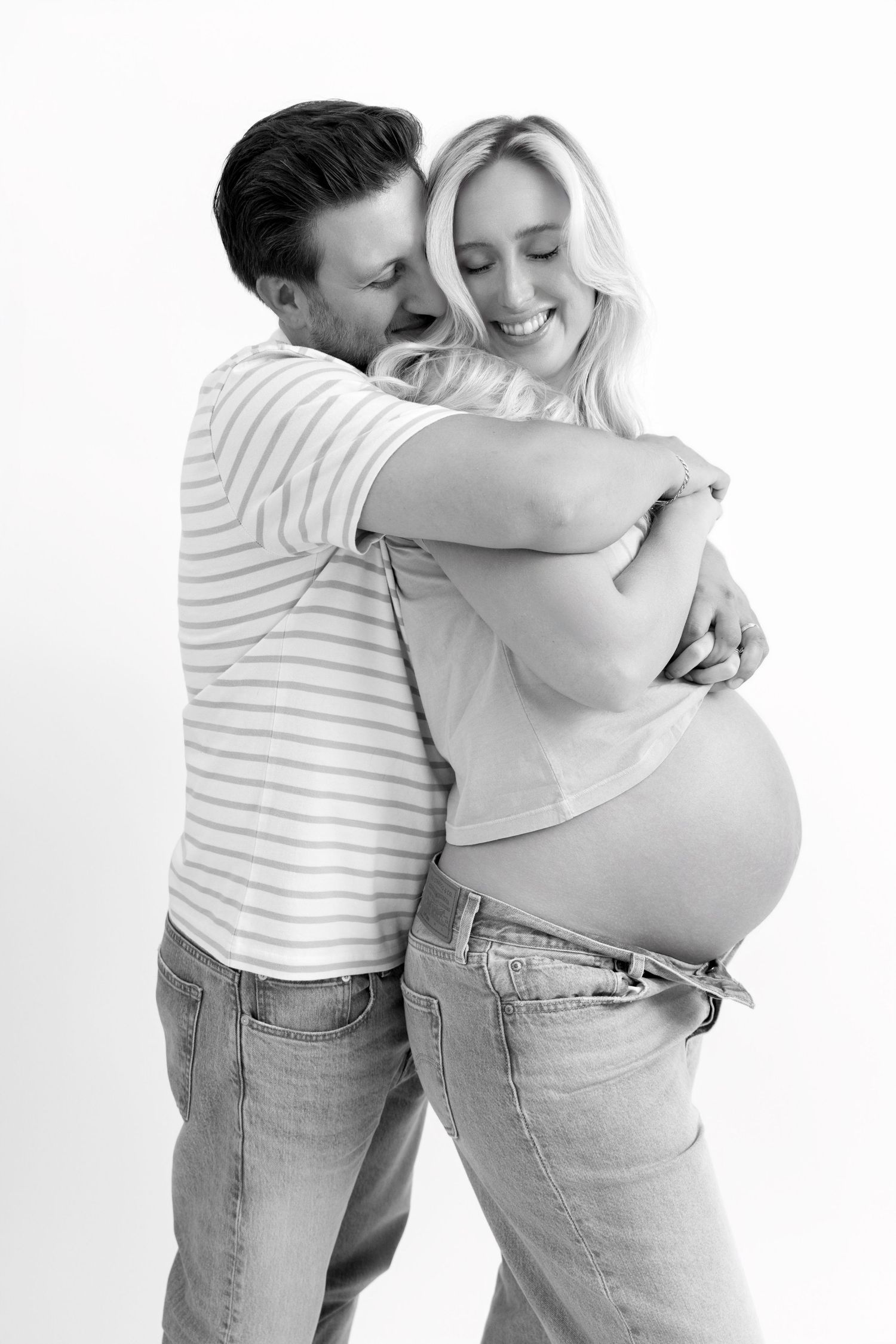 Three sequential black and white photos show a tender embrace between two people wearing striped shirts and jeans.
