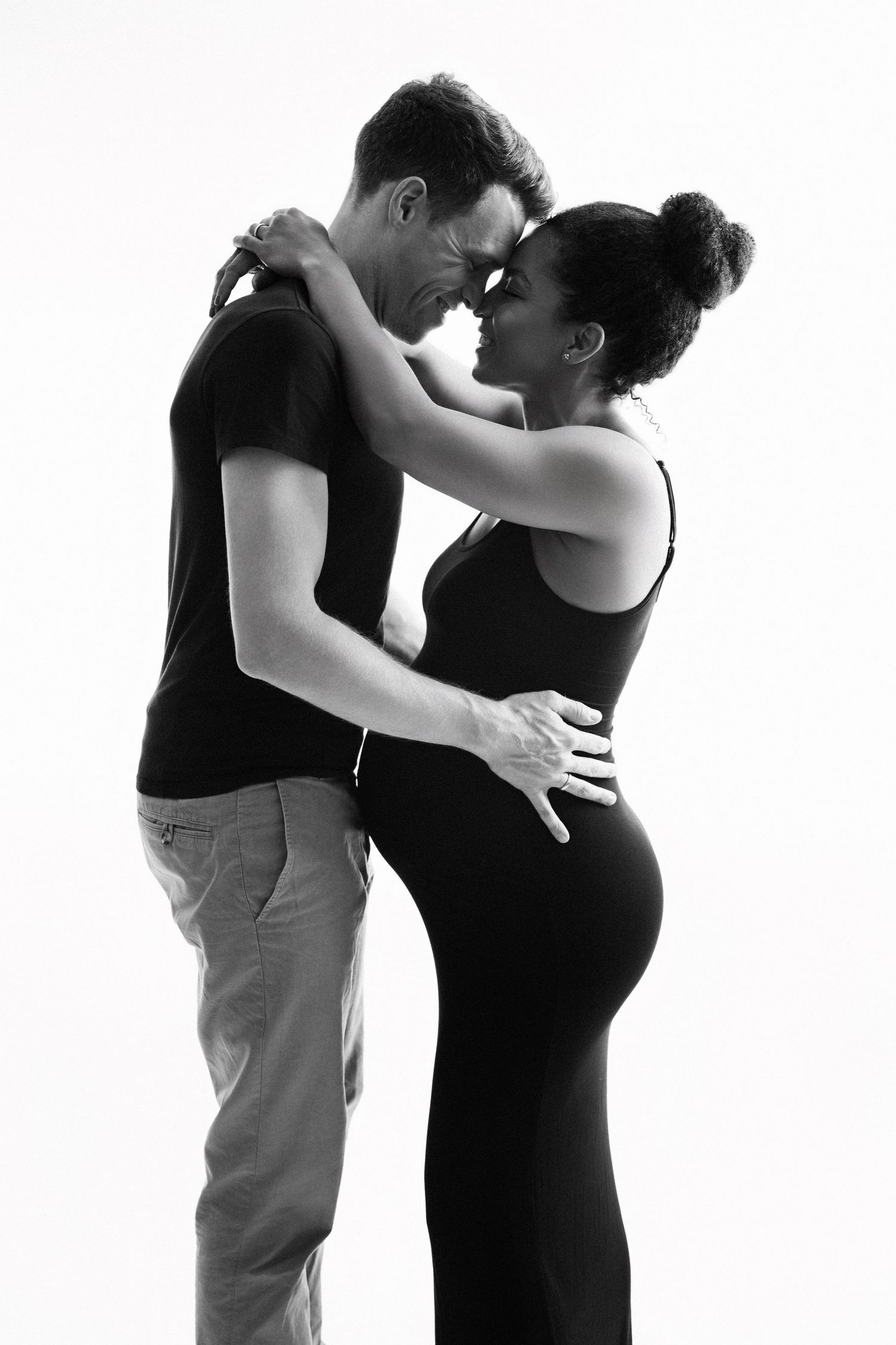 Three black and white silhouettes of couples embracing and dancing in an intimate sequence against a white background.