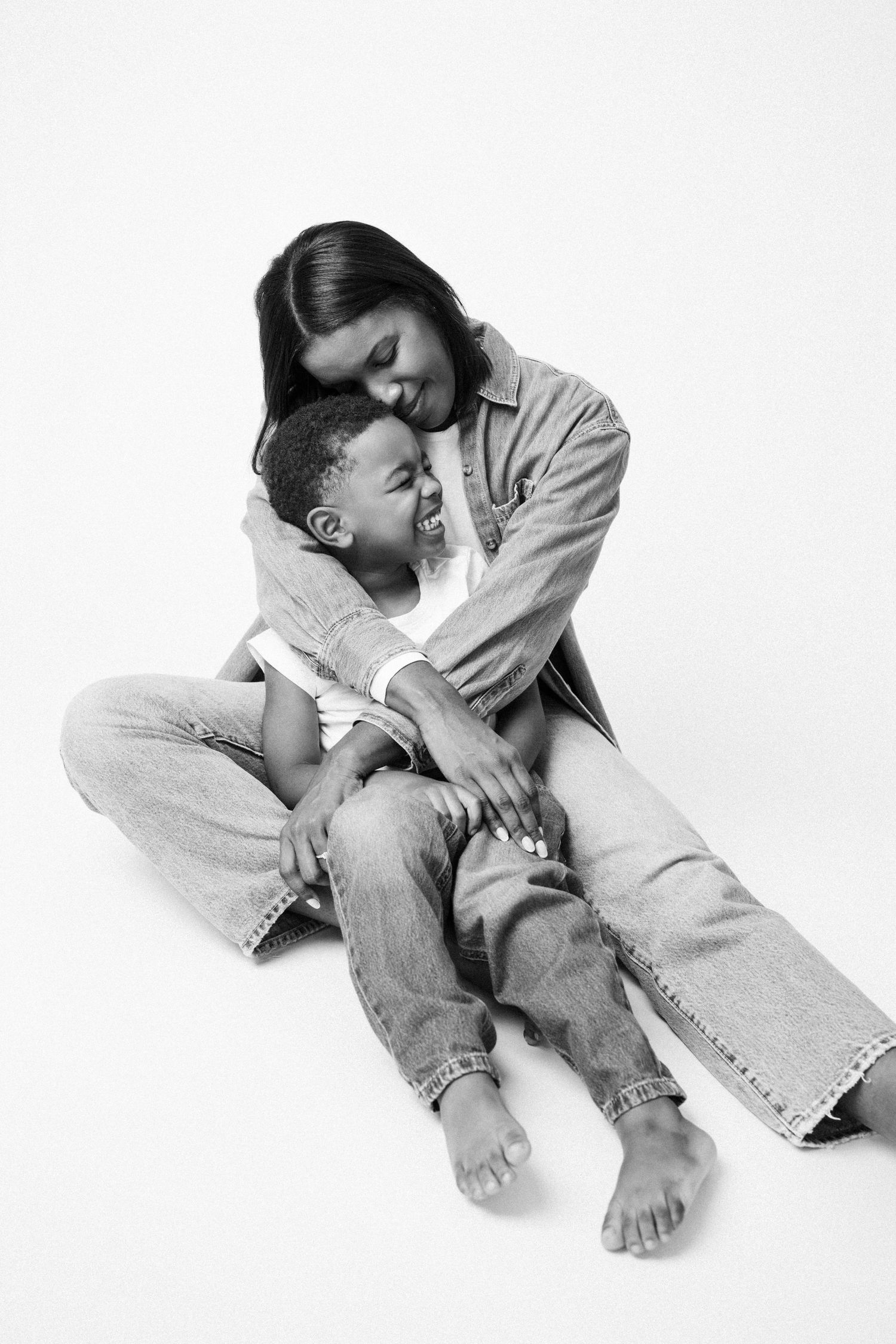 A series of black and white photographs showing someone curled up on the floor in casual denim attire.