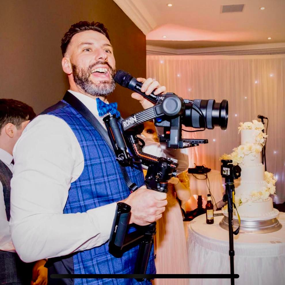 Professional videographers with cameras filming at an indoor wedding reception.