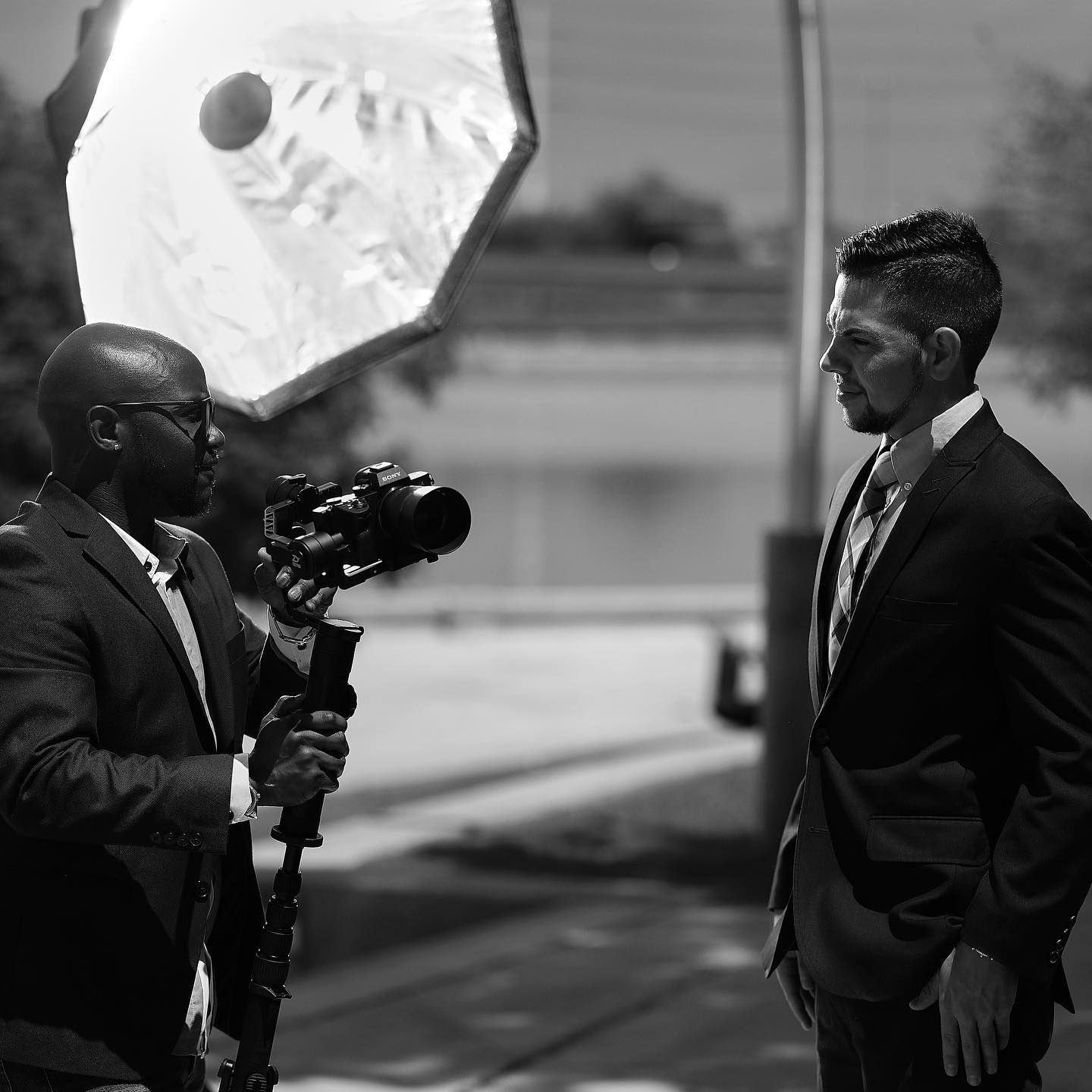 A black and white photo sequence shows a person in a suit taking pictures with a vintage camera.