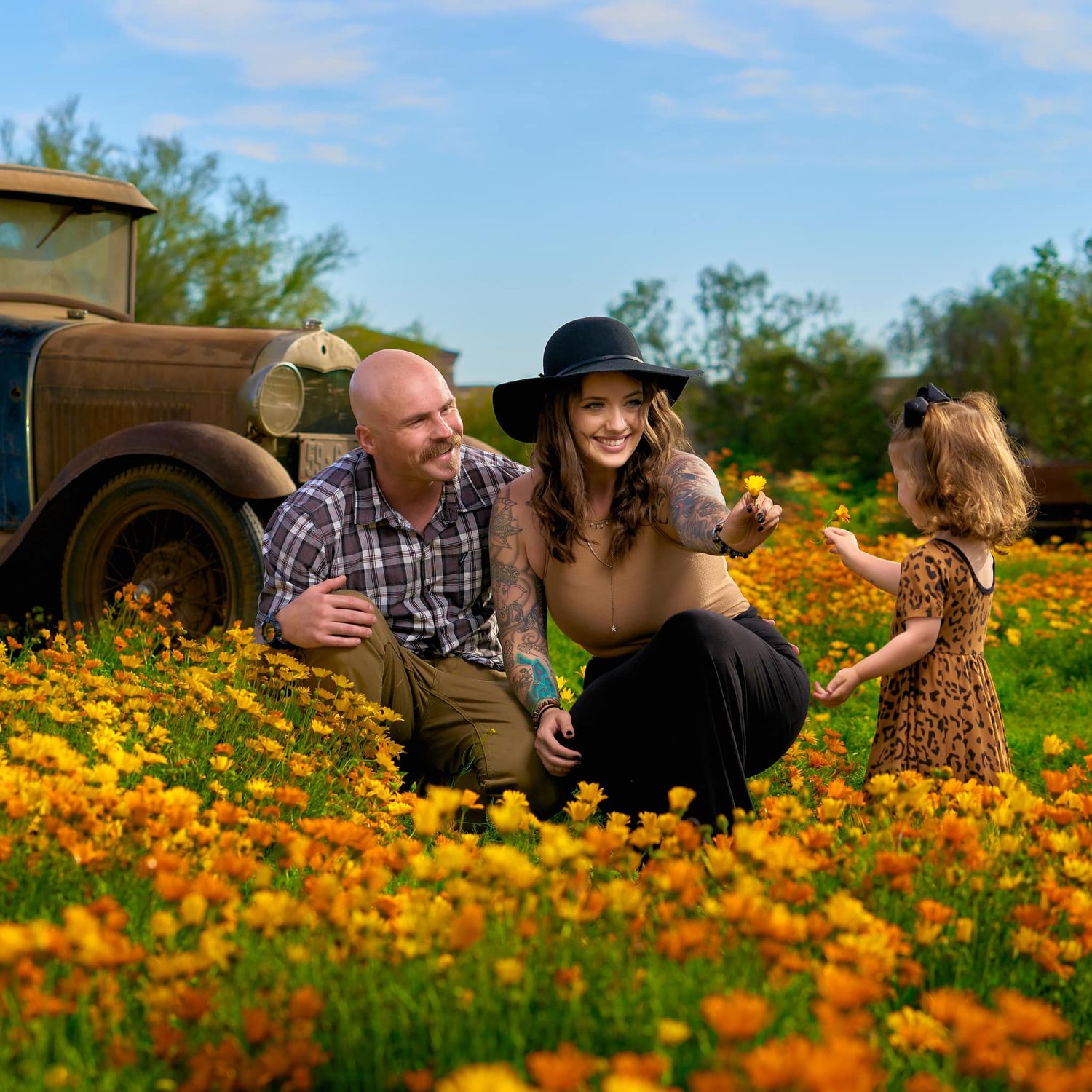 Candid family moments captured in blooming orange wildflower field under blue skies. Photographer RL Davis