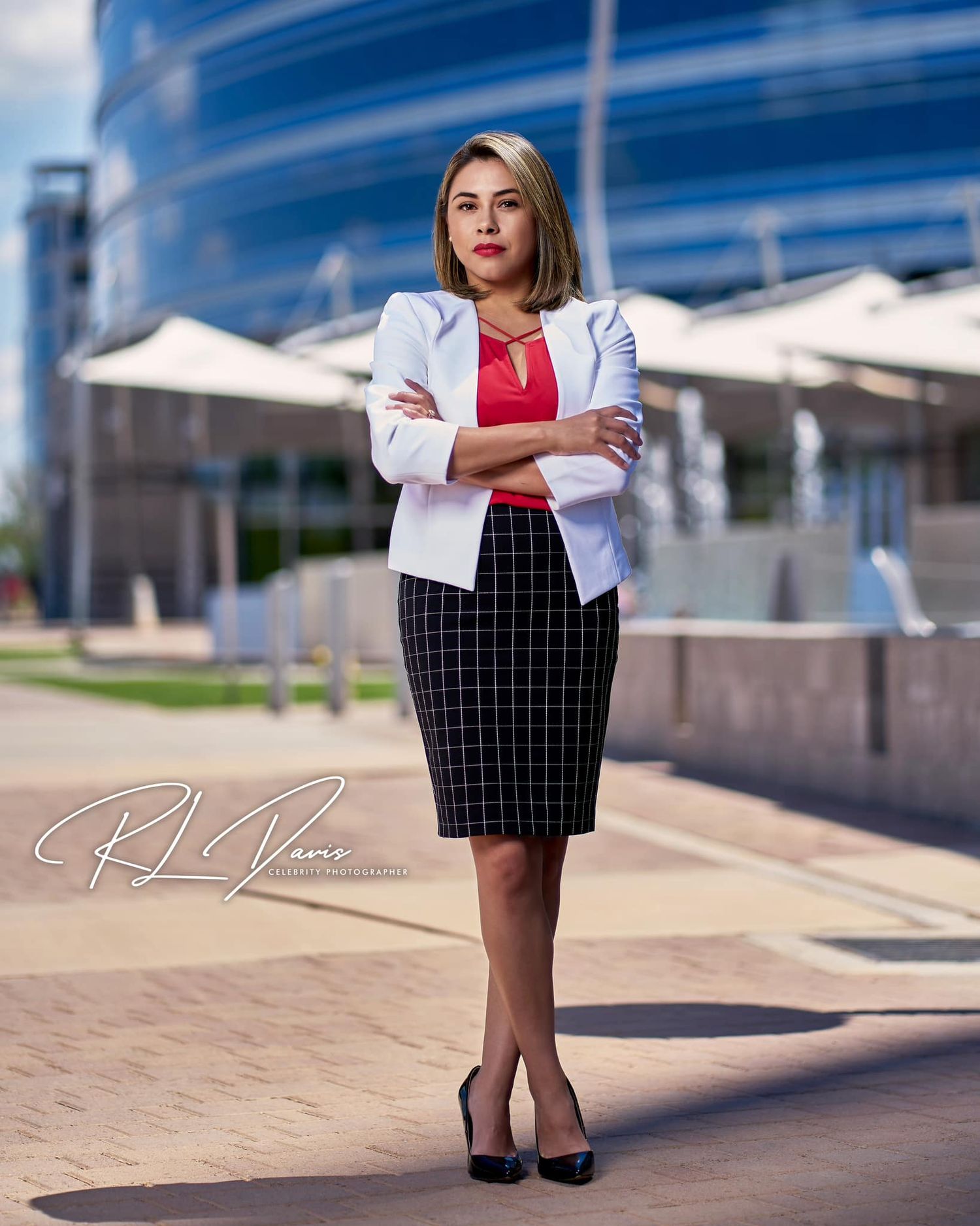 Professional portrait of woman in business attire standing confidently outside modern building. Photographer RL Davis