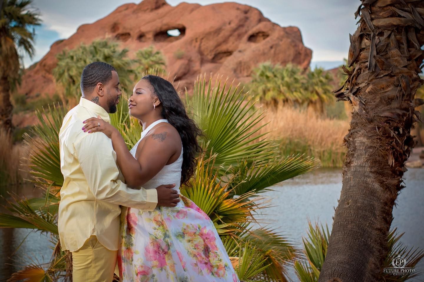 Romantic couple embracing near red rock formations at sunset. Photographer RL Davis