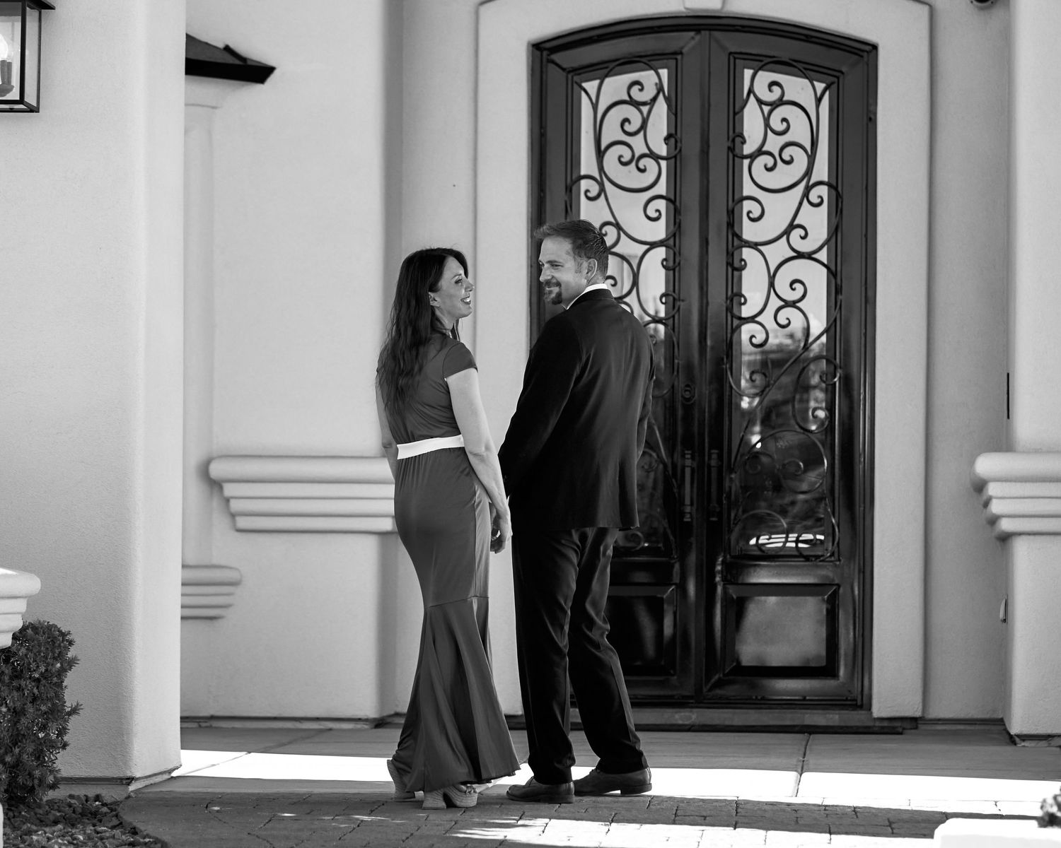 Exterior view of elegant home entrance with ornate iron door details. Photographer RL Davis