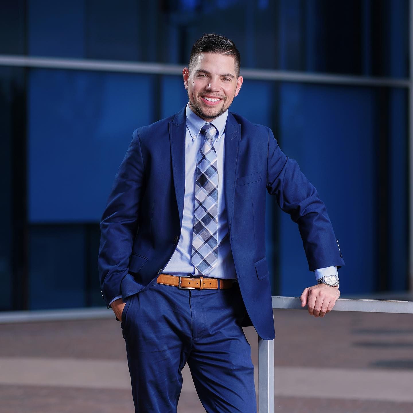 Professional man in navy suit and plaid tie poses outdoors. Photographer RL Davis