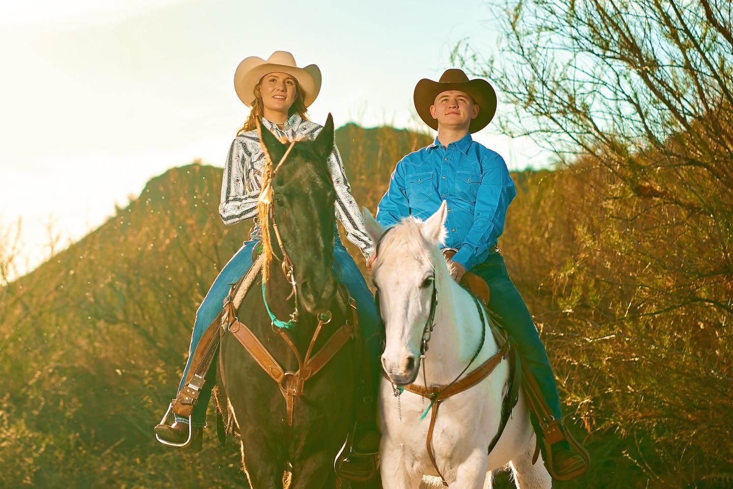 People riding horses along a desert trail during golden hour. Photographer RL Davis