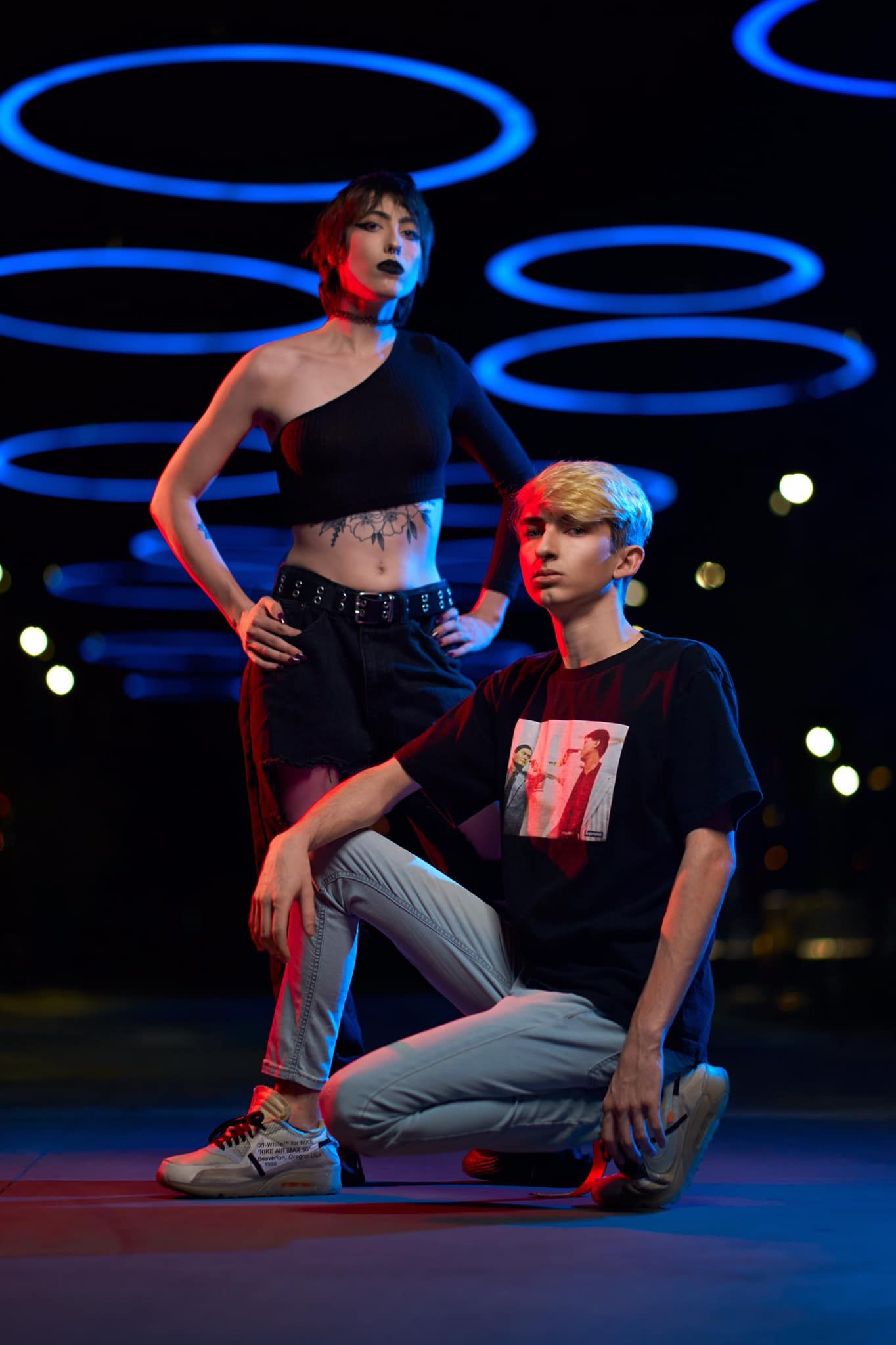 Urban dancers perform on dark stage with glowing blue circular lighting effects. Photographer RL Davis