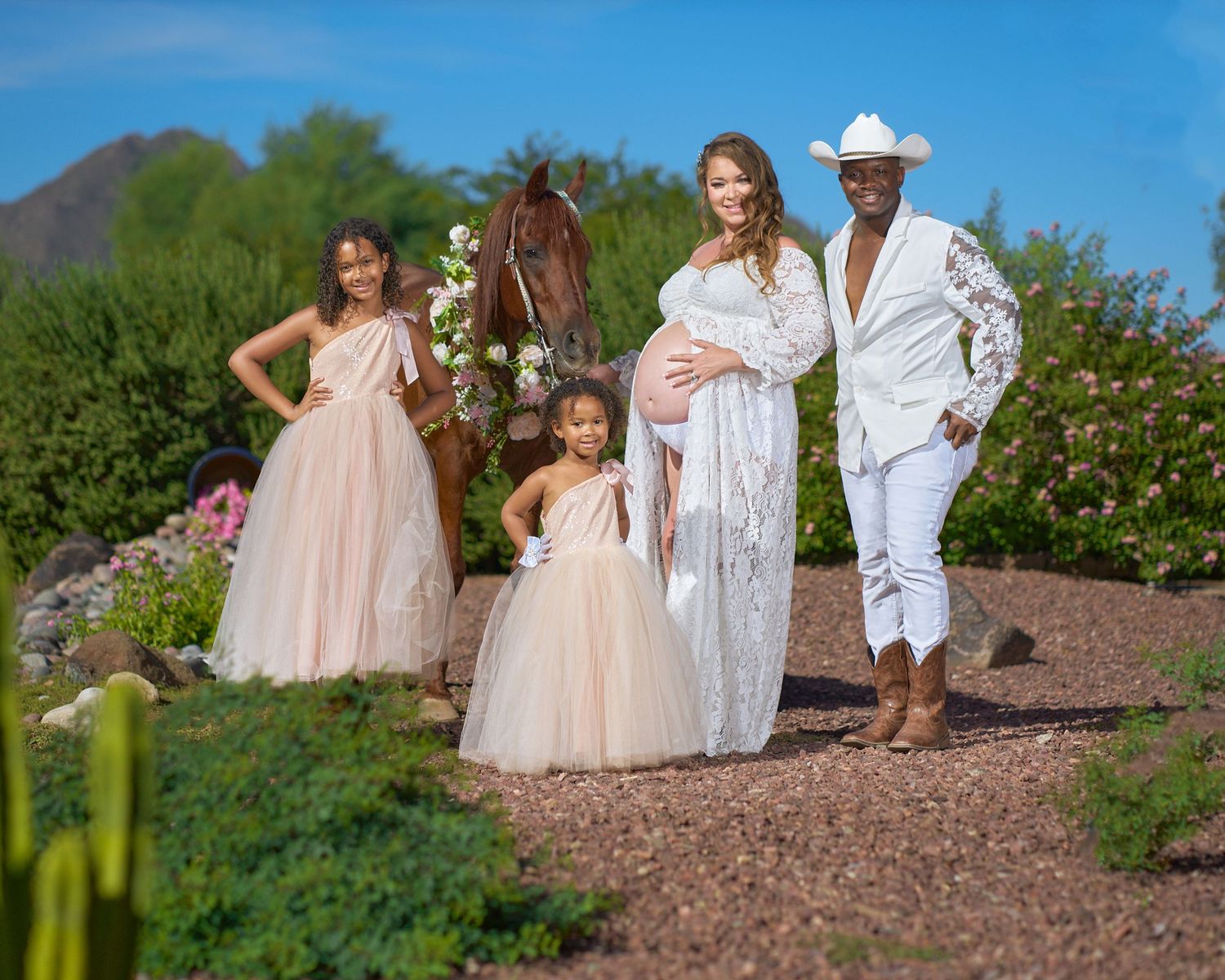 Family photo session in desert landscape with flowing dresses and western attire. Photographer RL Davis