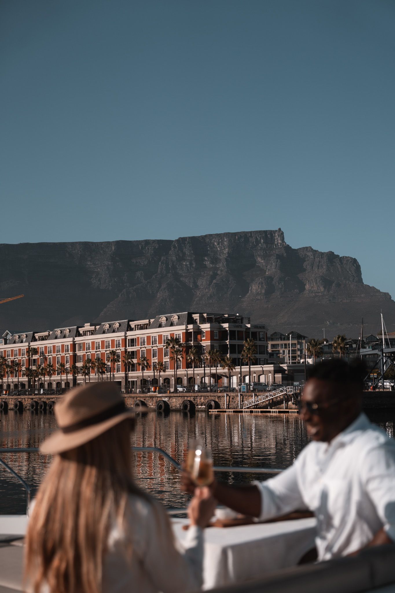 Waterfront dining scene with Table Mountain backdrop in Cape Town at dusk.