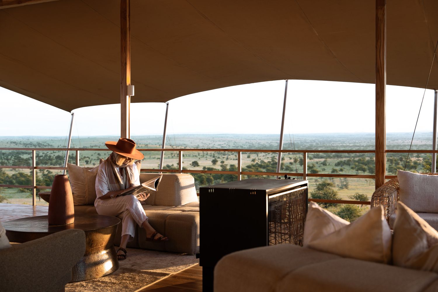 Luxurious safari tent interior with panoramic views of the savanna landscape.