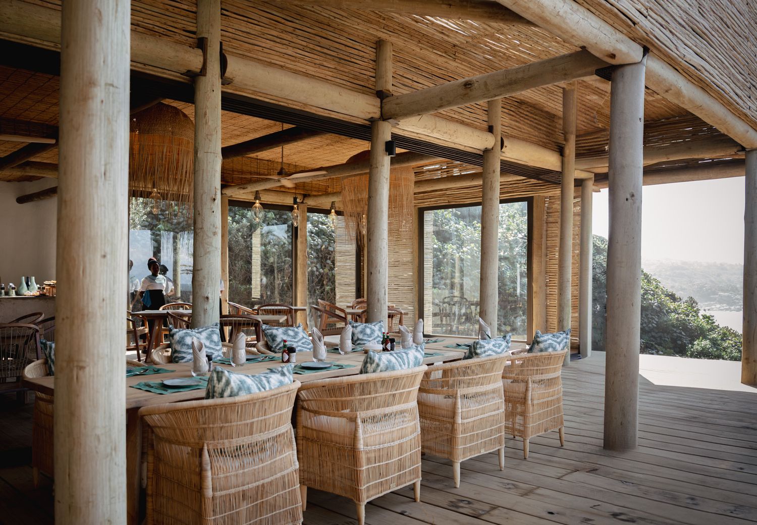 Rustic covered patio with wooden columns and comfortable seating areas for outdoor relaxation.