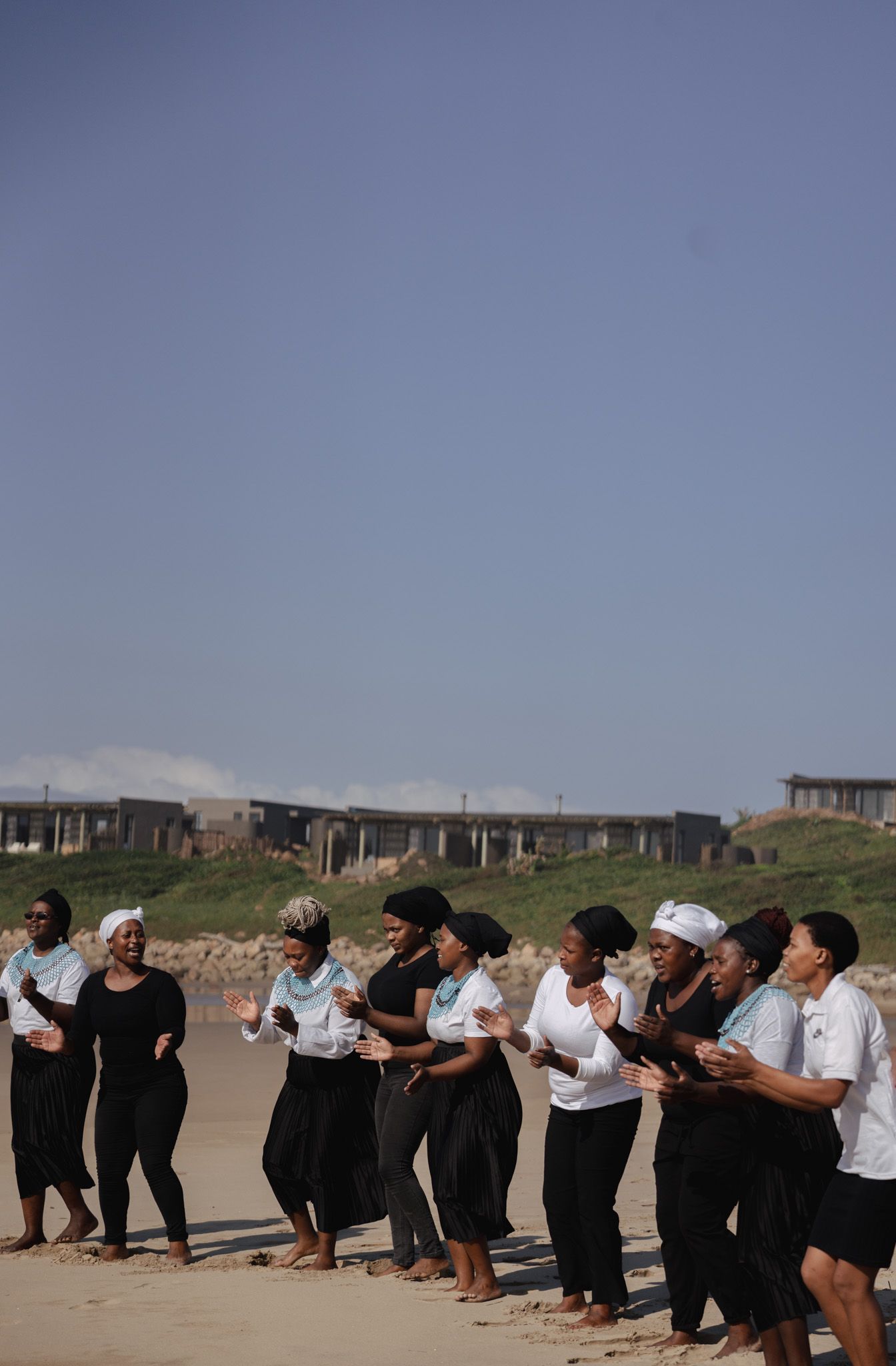 Group of dancers lined up outdoors performing a choreographed routine in matching outfits.