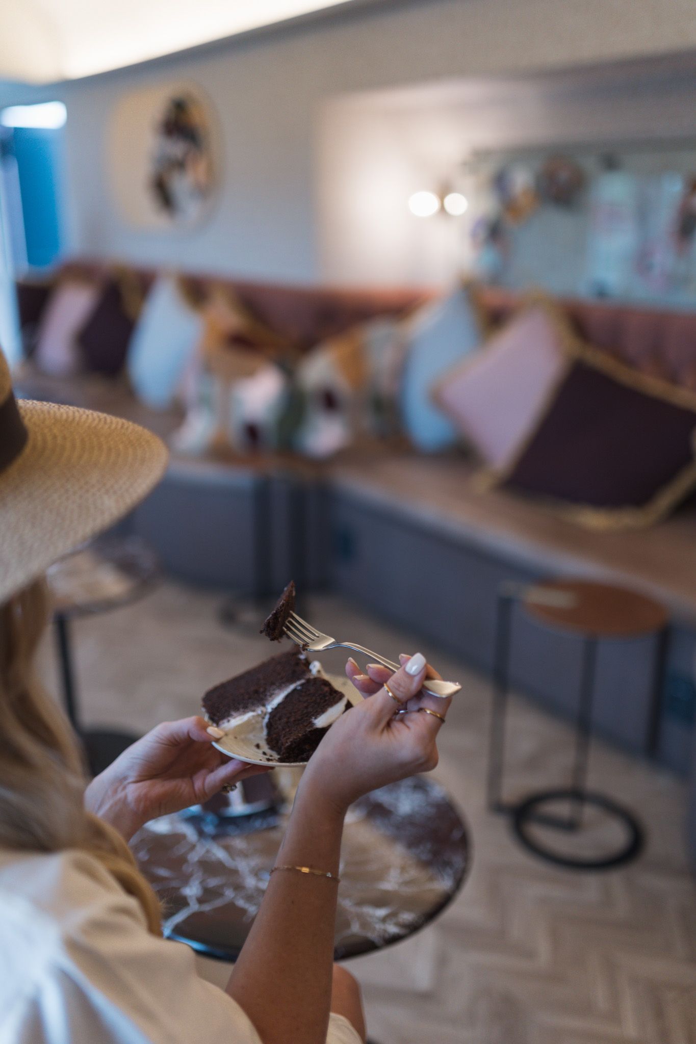 Hands holding smartphone to capture food photography in restaurant setting.