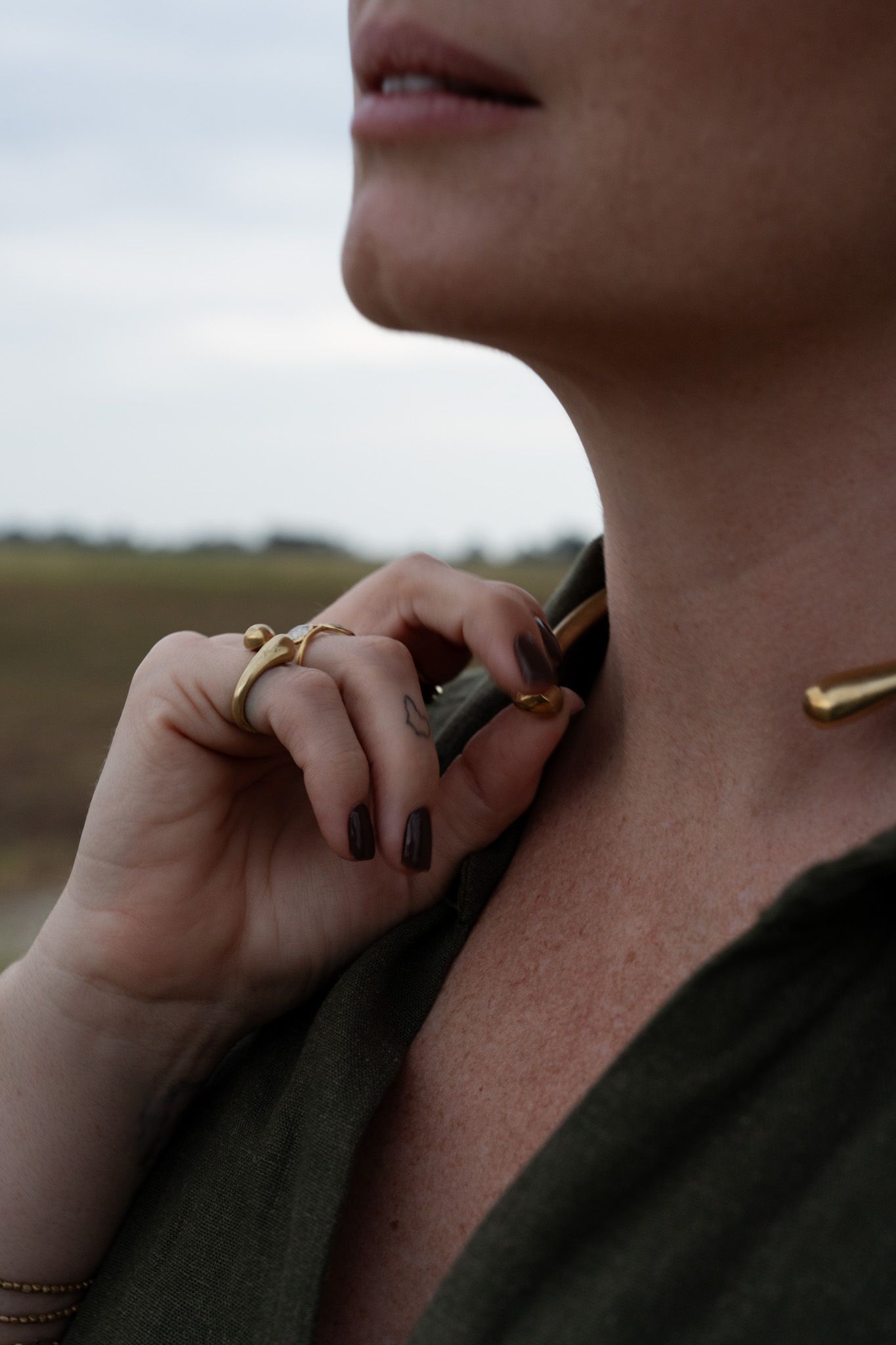 Close-up sequence showing hands adjusting a dark fabric collar against a blurred outdoor background.