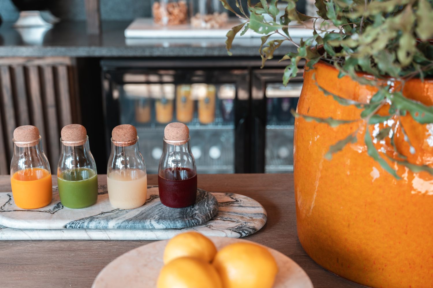 Orange-tinted restaurant interior with elegant table settings and natural decor.