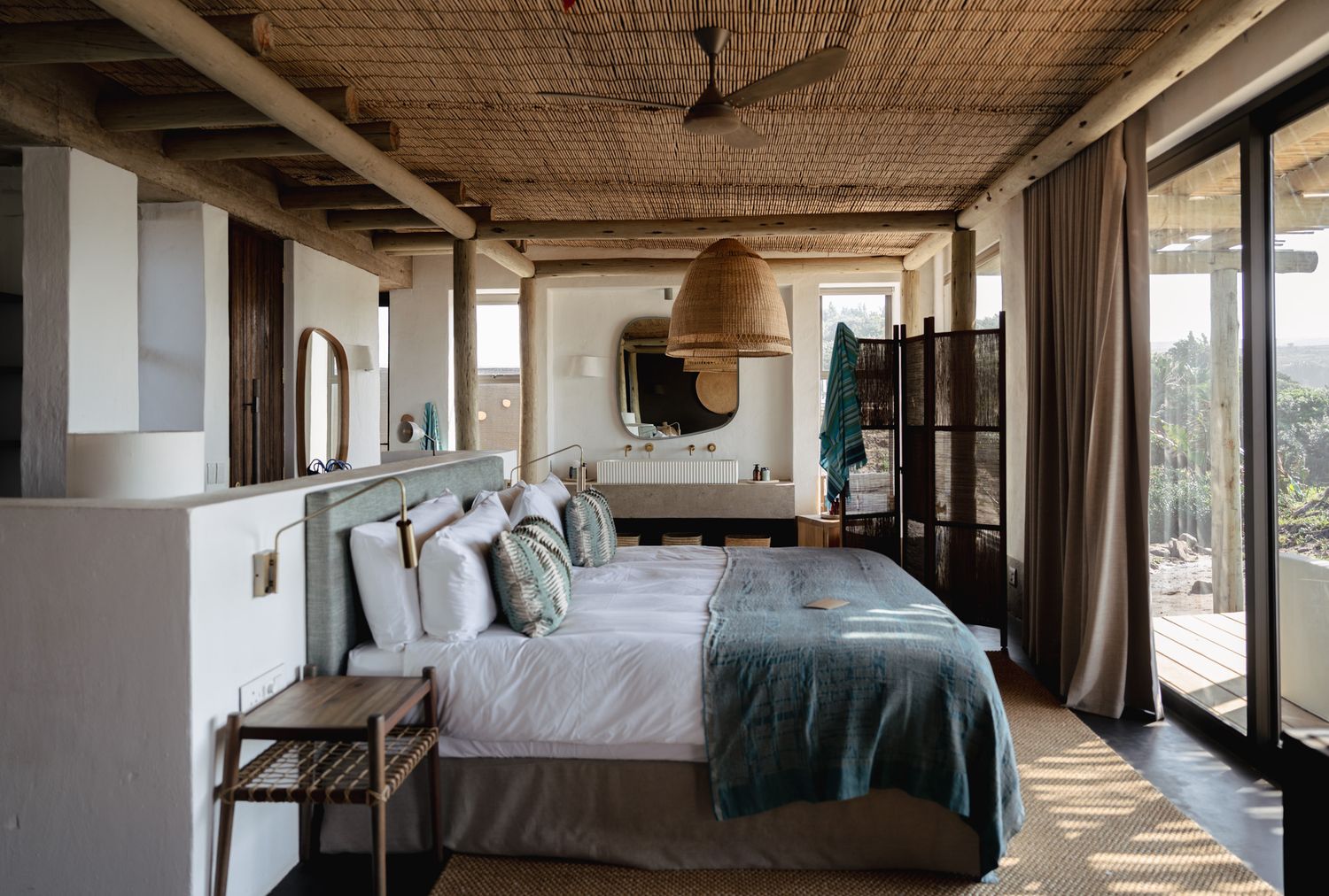 Spacious beachfront bedroom with large windows and contemporary furnishings.