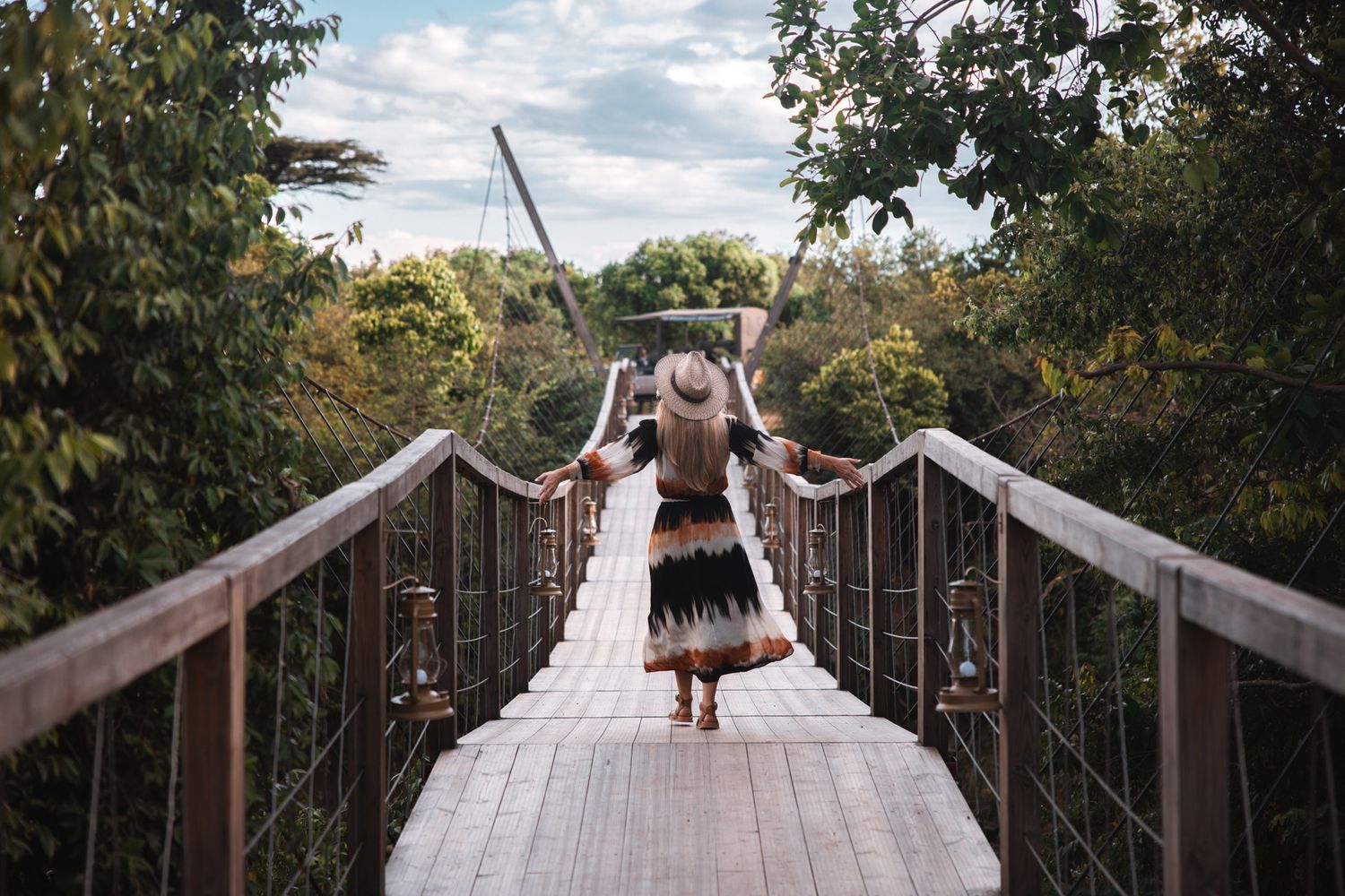 Wooden suspension bridge stretching across a scenic natural landscape.
