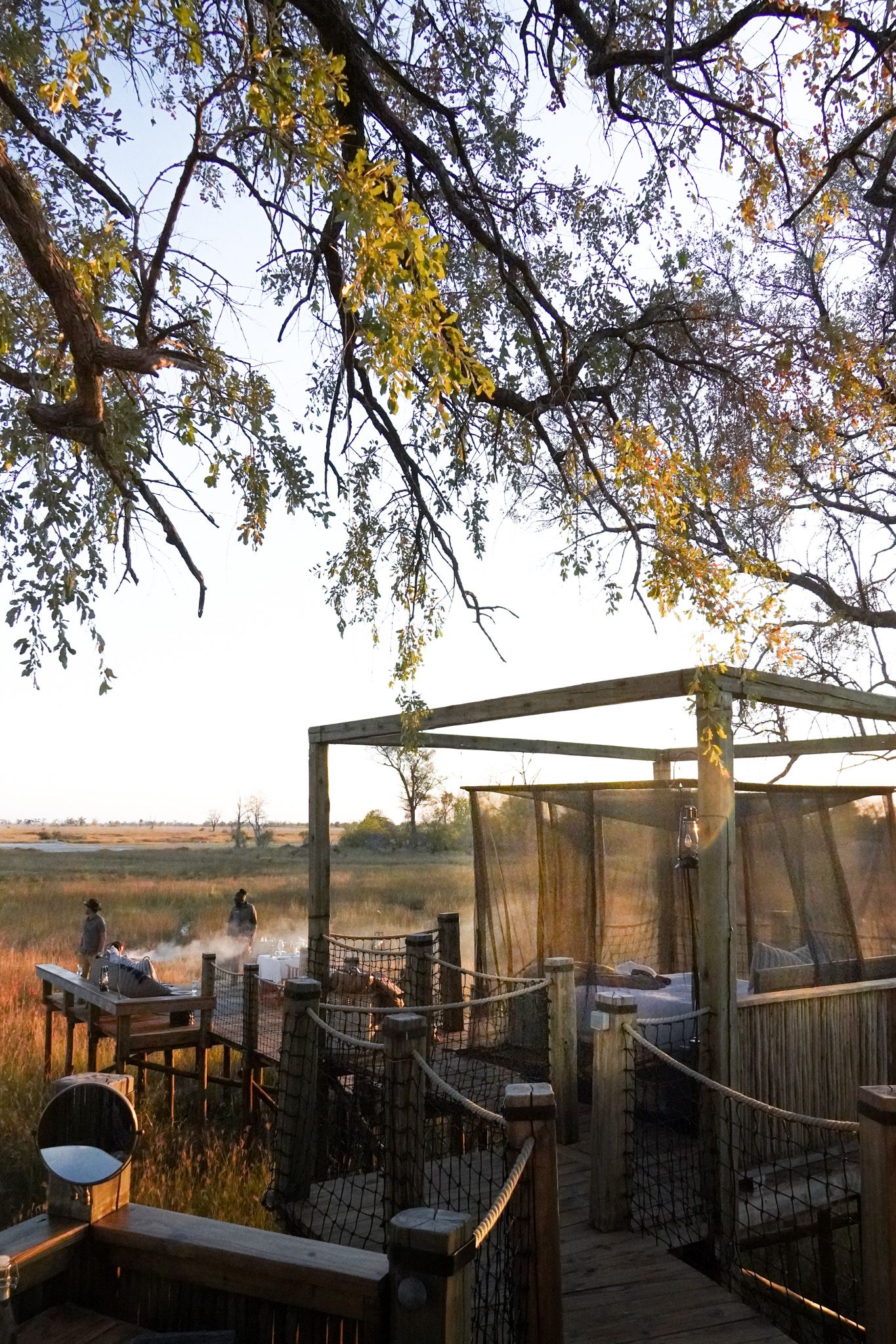 Outdoor deck with chairs overlooking autumn landscape under yellow-leaved trees.