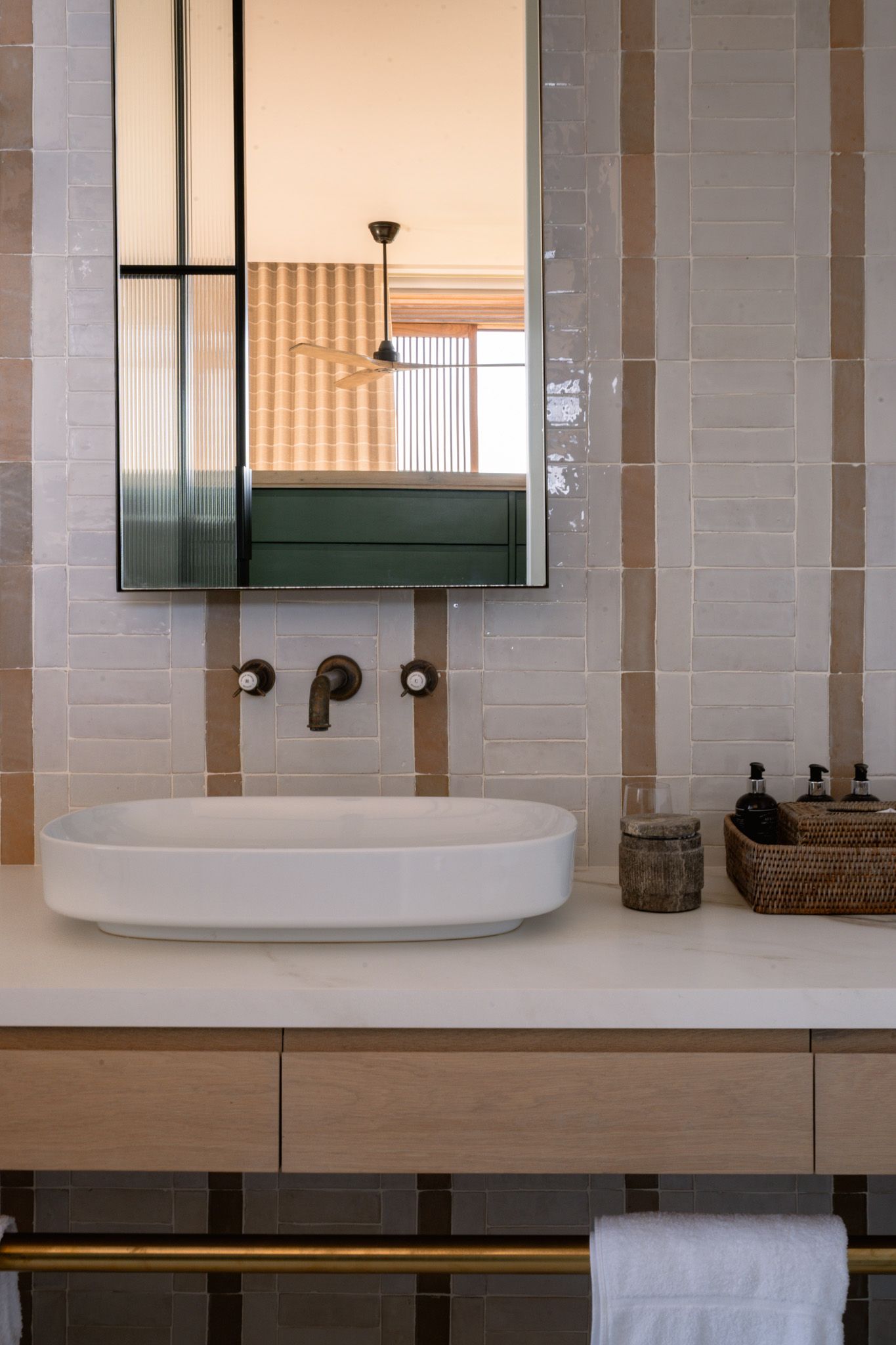 Modern bathroom vanity featuring a white vessel sink, wall-mounted faucets, and minimalist design.