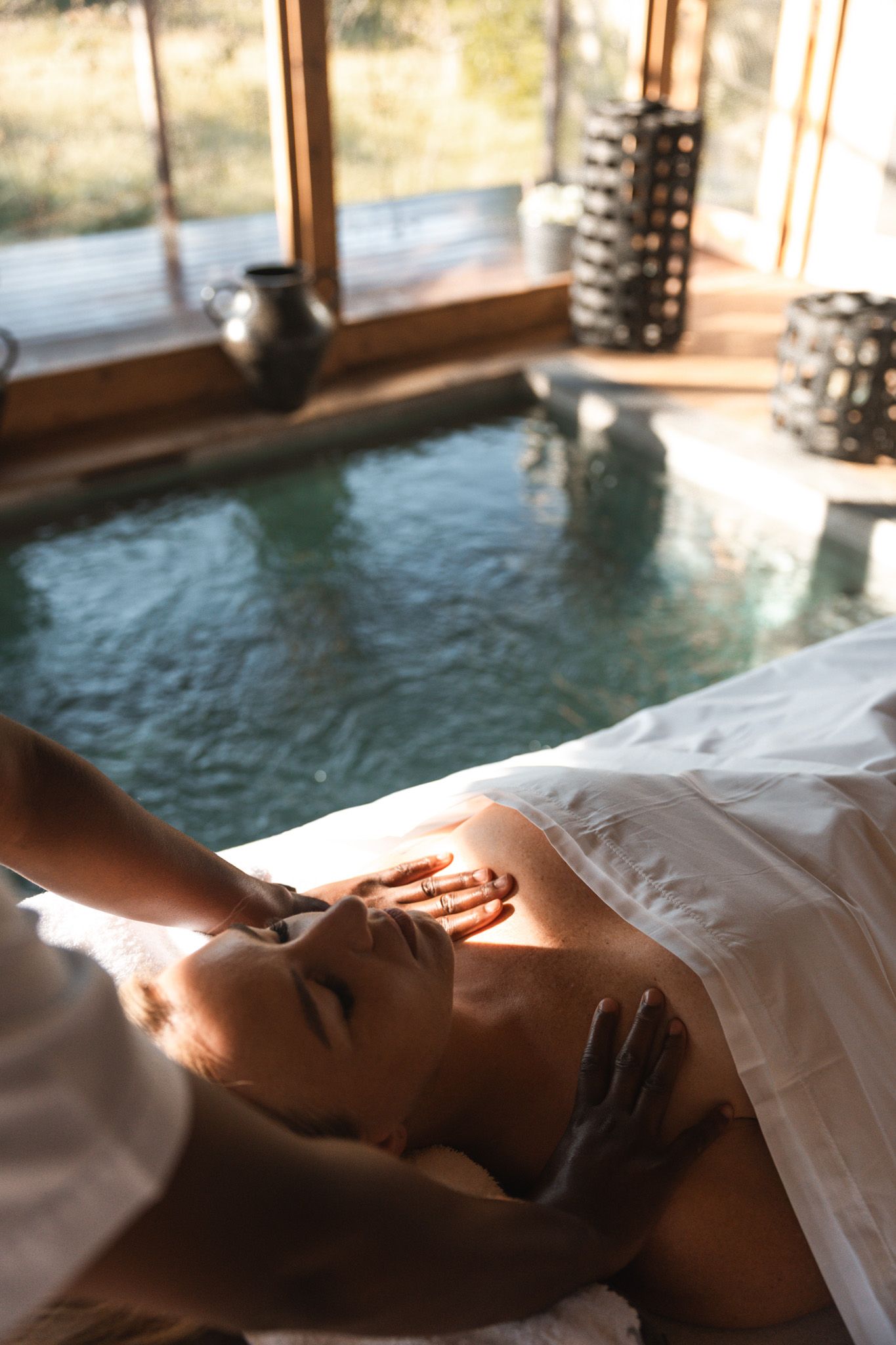 Relaxing spa treatment scene with sunlight streaming through windows.