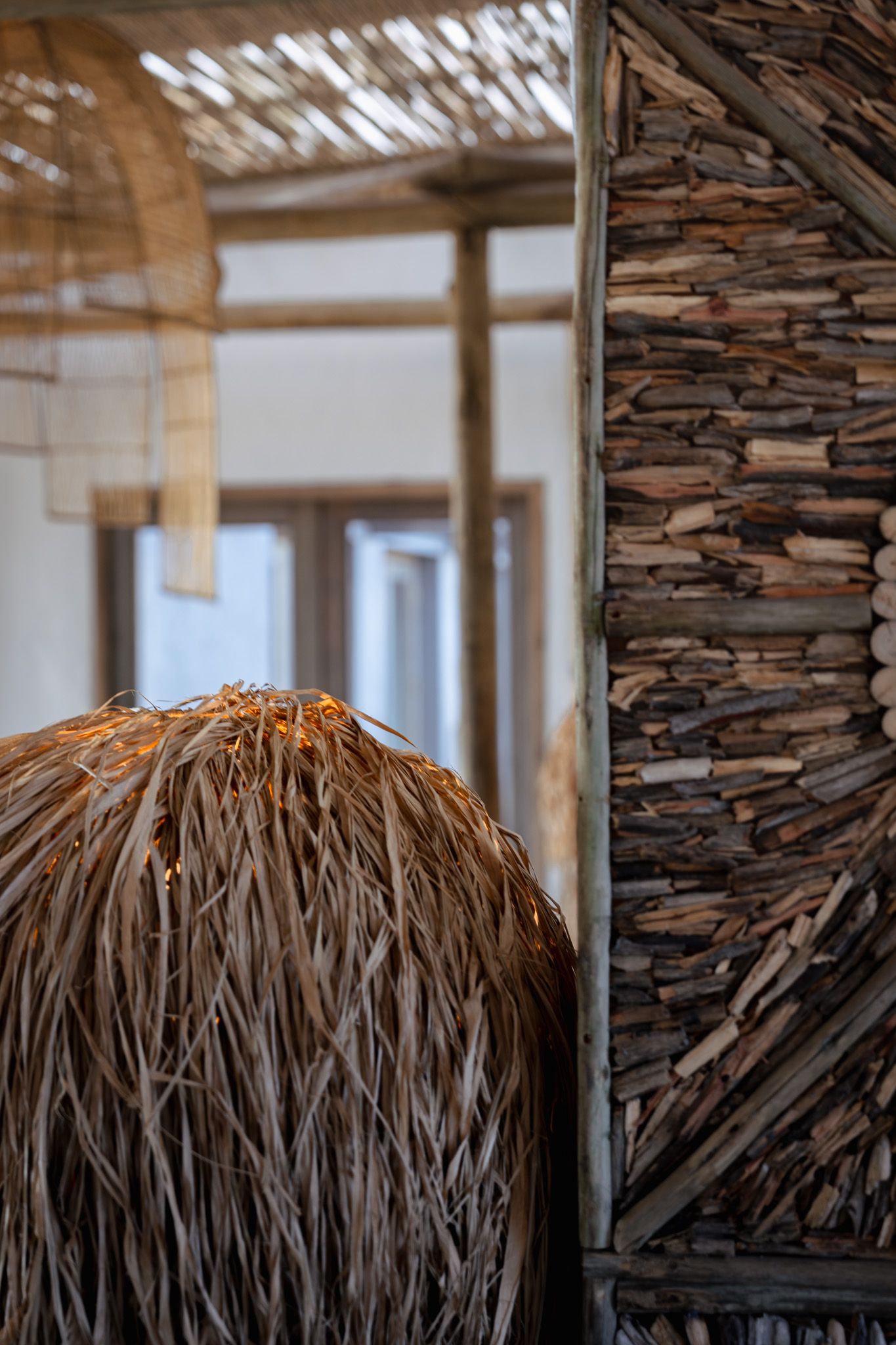 Natural thatched roof detail with woven textures and rustic stone wall elements.