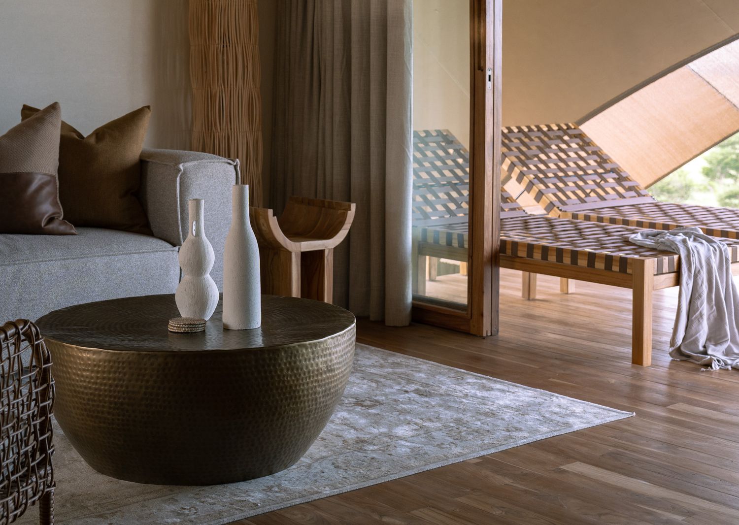 Contemporary living space with bowl table, woven furniture, and minimalist decor.