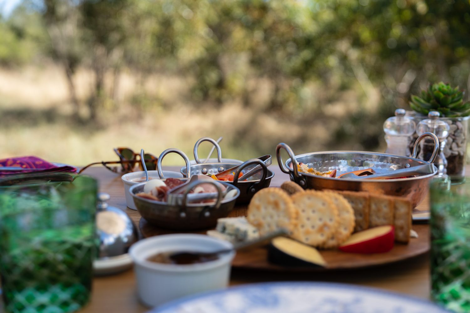 Spread of food and drinks on an outdoor table with natural lighting.