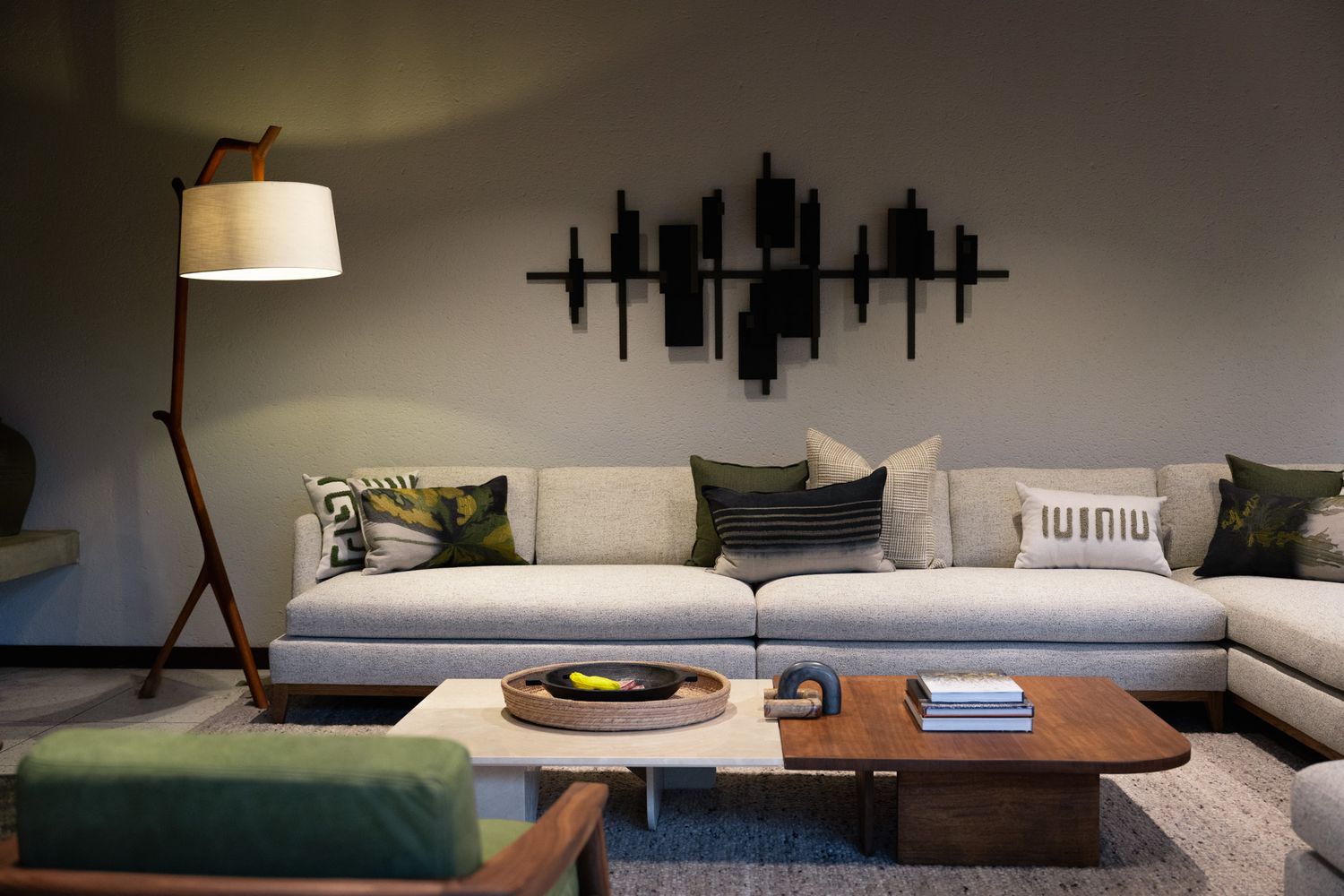 Contemporary living room featuring grey sectional sofa and abstract metal wall art.