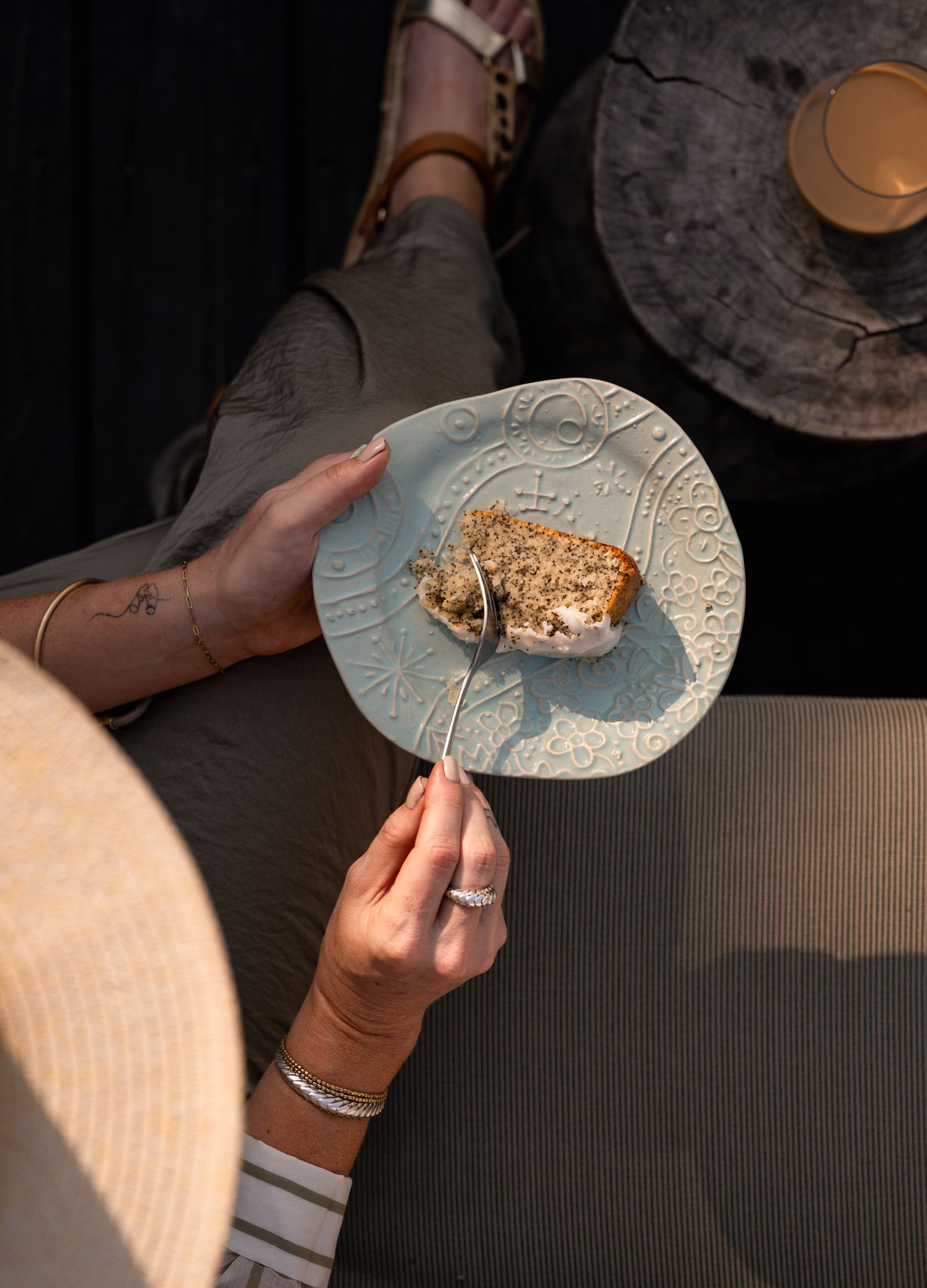 Overhead view of hands holding ornate plate with slice of rustic bread.