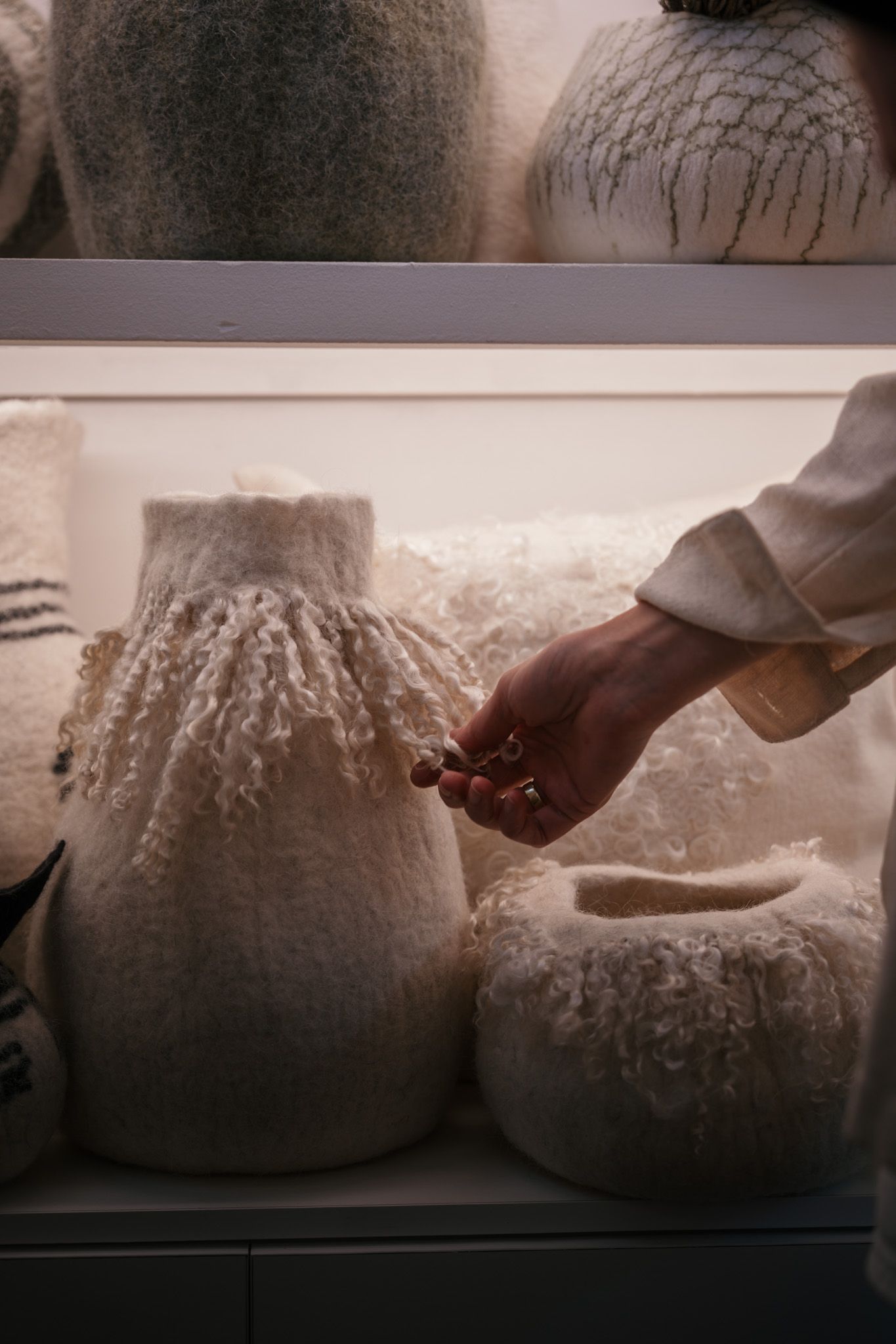 Hands kneading raw dough on a floured surface in soft natural light.