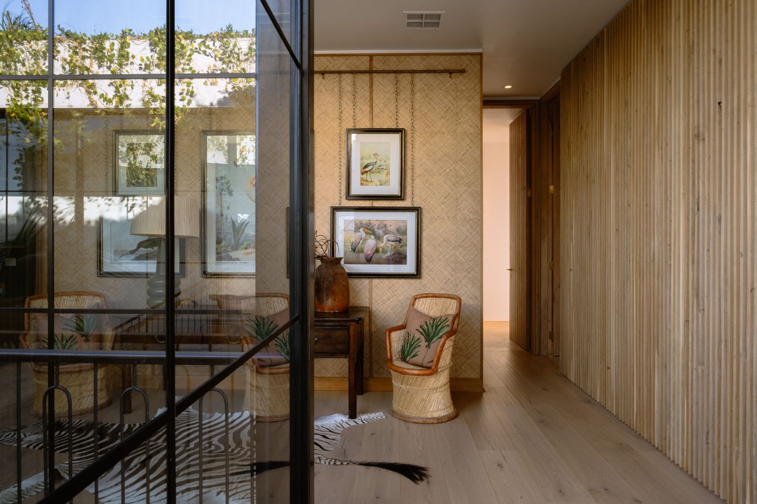 Contemporary hallway with wooden paneling, glass partitions, and natural lighting.
