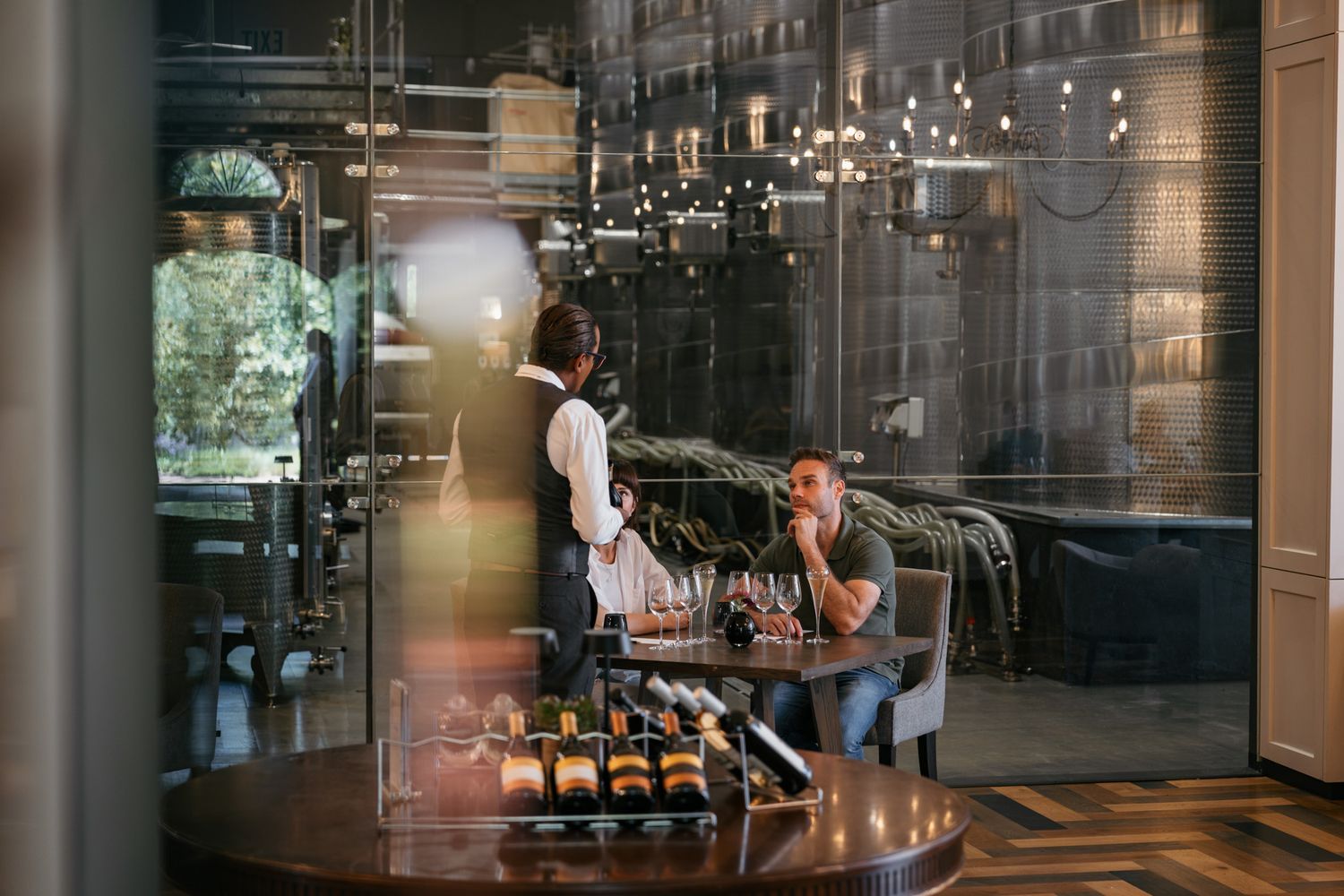 Modern restaurant interior with glass walls and industrial design elements.