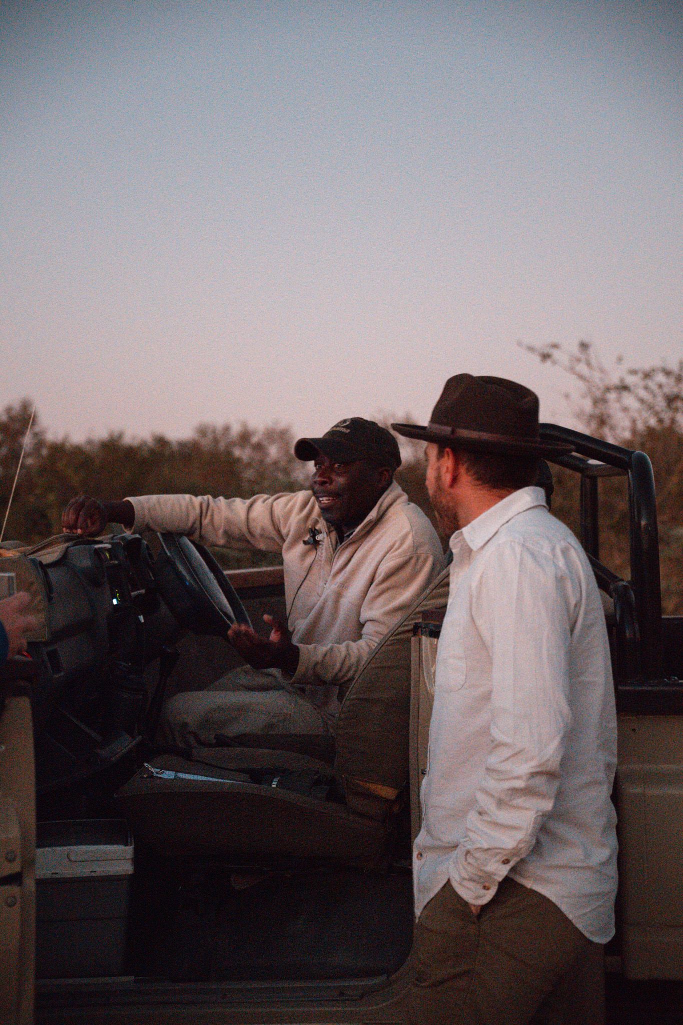 Evening scene of outdoor safari dining area with ambient lighting.