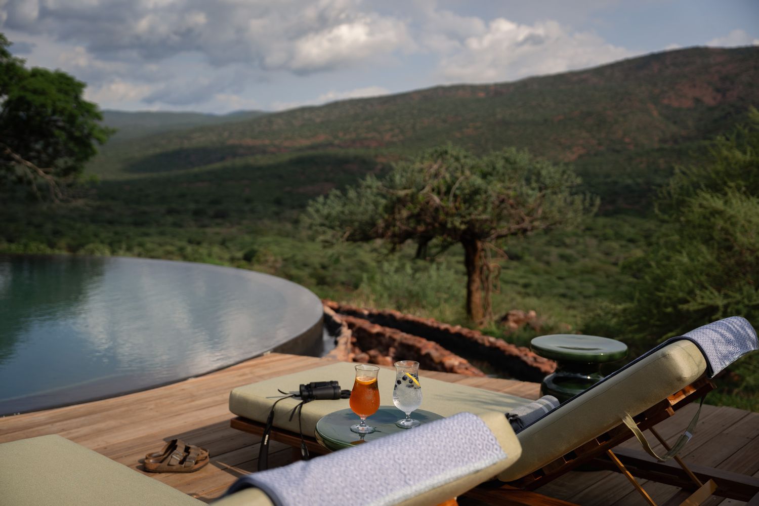 Panoramic view of a luxury safari lodge overlooking a scenic mountain landscape.