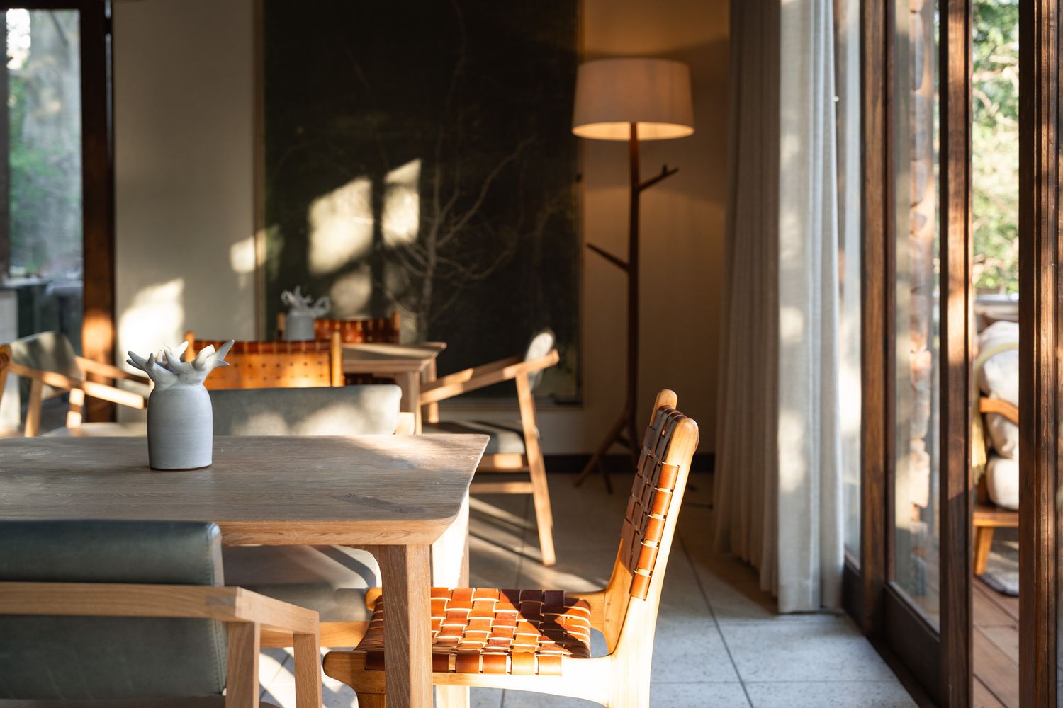 Sunlit dining room interior with wooden chairs and natural lighting.