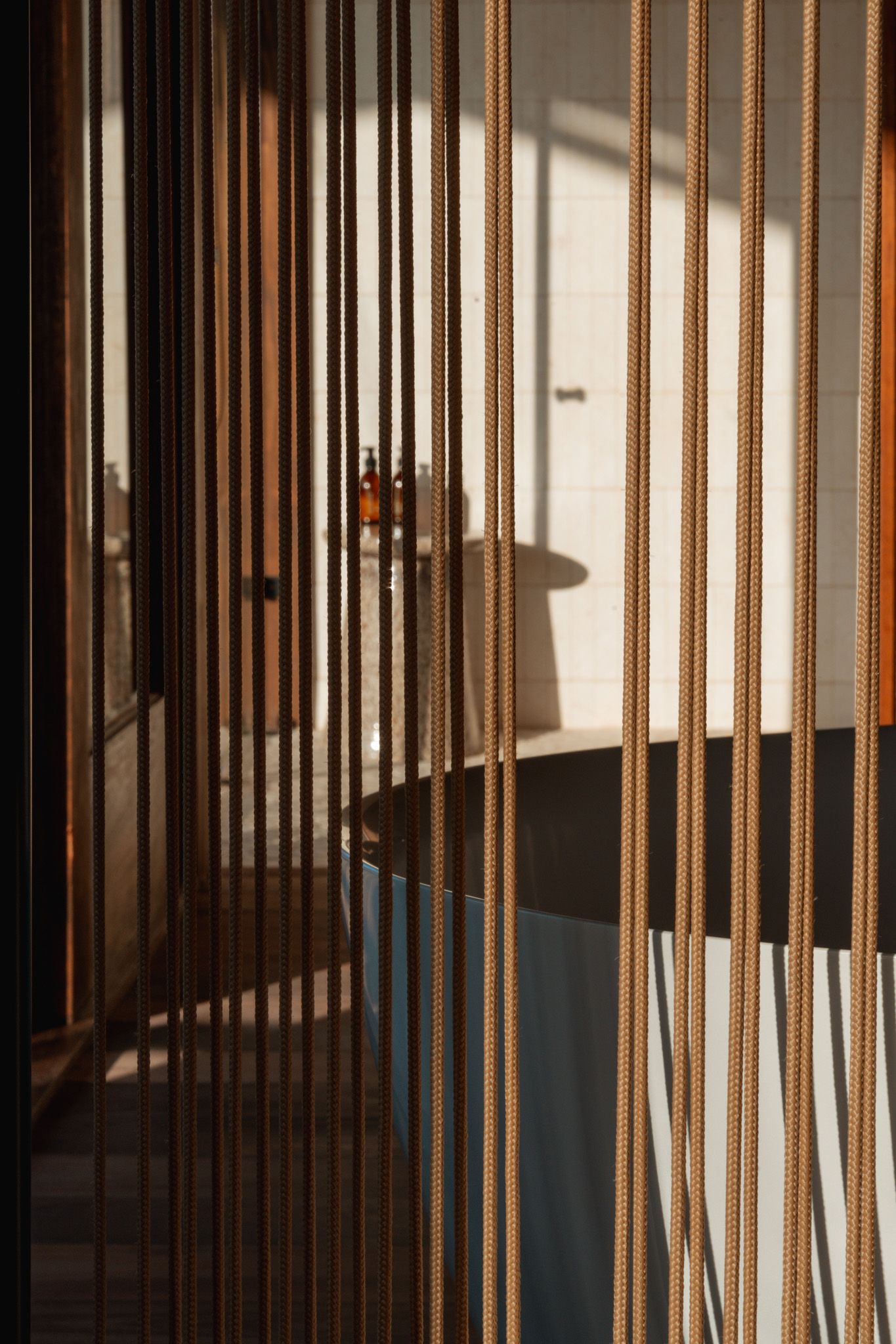 Artistic pattern of vertical wooden slats creating shadows and light in an interior space.