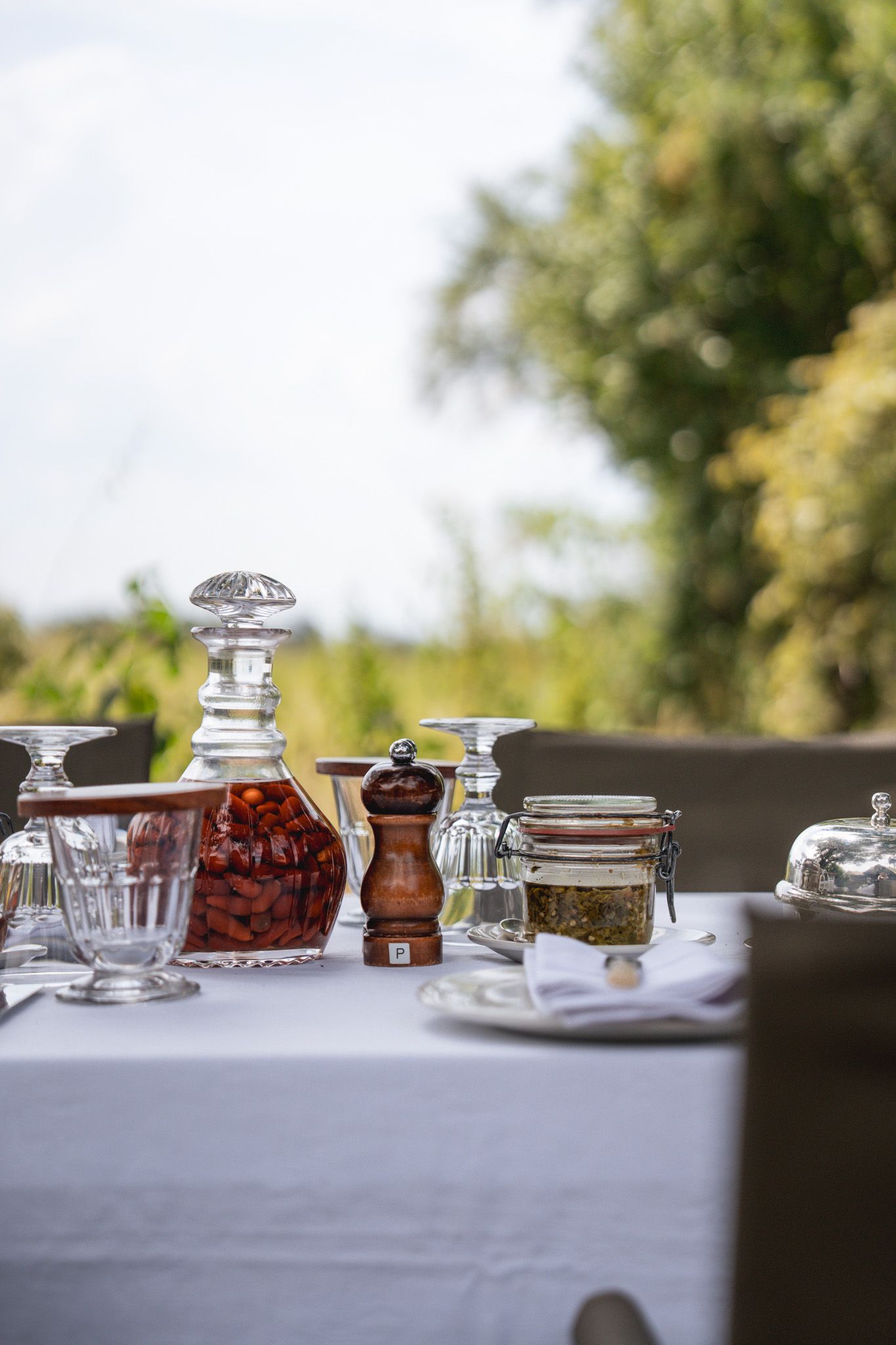 Elegant table setting with crystal decanters, spice jars and glassware.