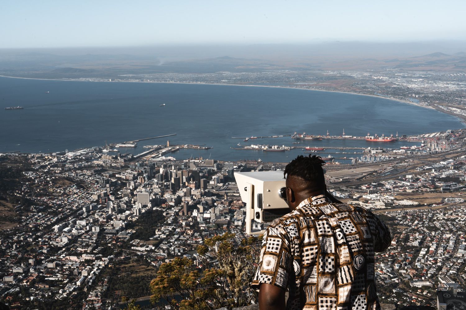 Aerial panoramic views of a coastal city and harbor showing urban development along the shoreline.